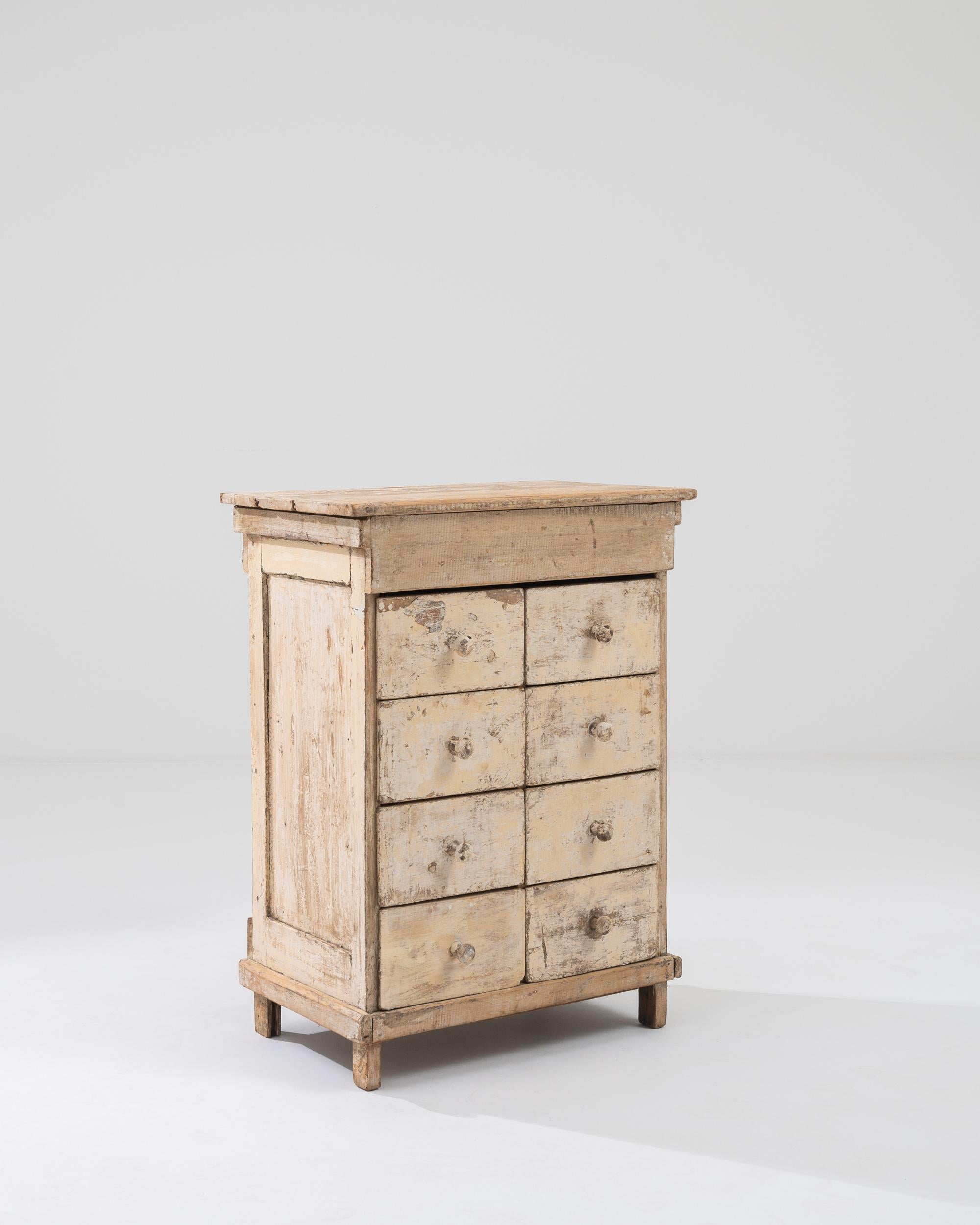 A wooden chest of drawers made in France circa 1900. This rustic and simple drawer chest is a charming picture of resiliency, its weathered surface telling the story of its age. A creamy beige and soft brown patina touches each of its sides and