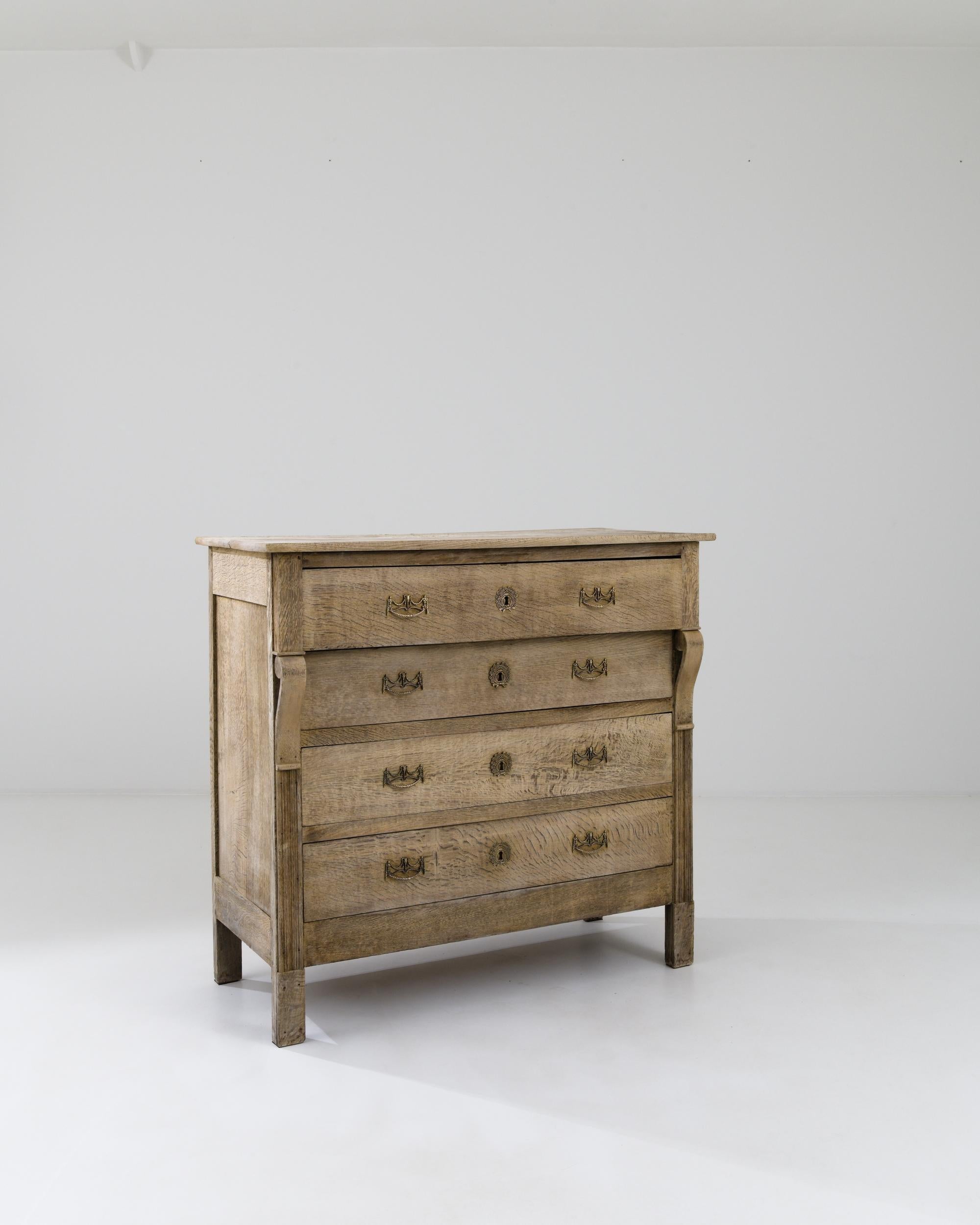 A wooden chest of drawers made in 1900s France. This handsome and astute dresser greets one with a pleasant demeanor, both dignified and approachable. The surface of the wood has been carefully restored through a bleaching process which both