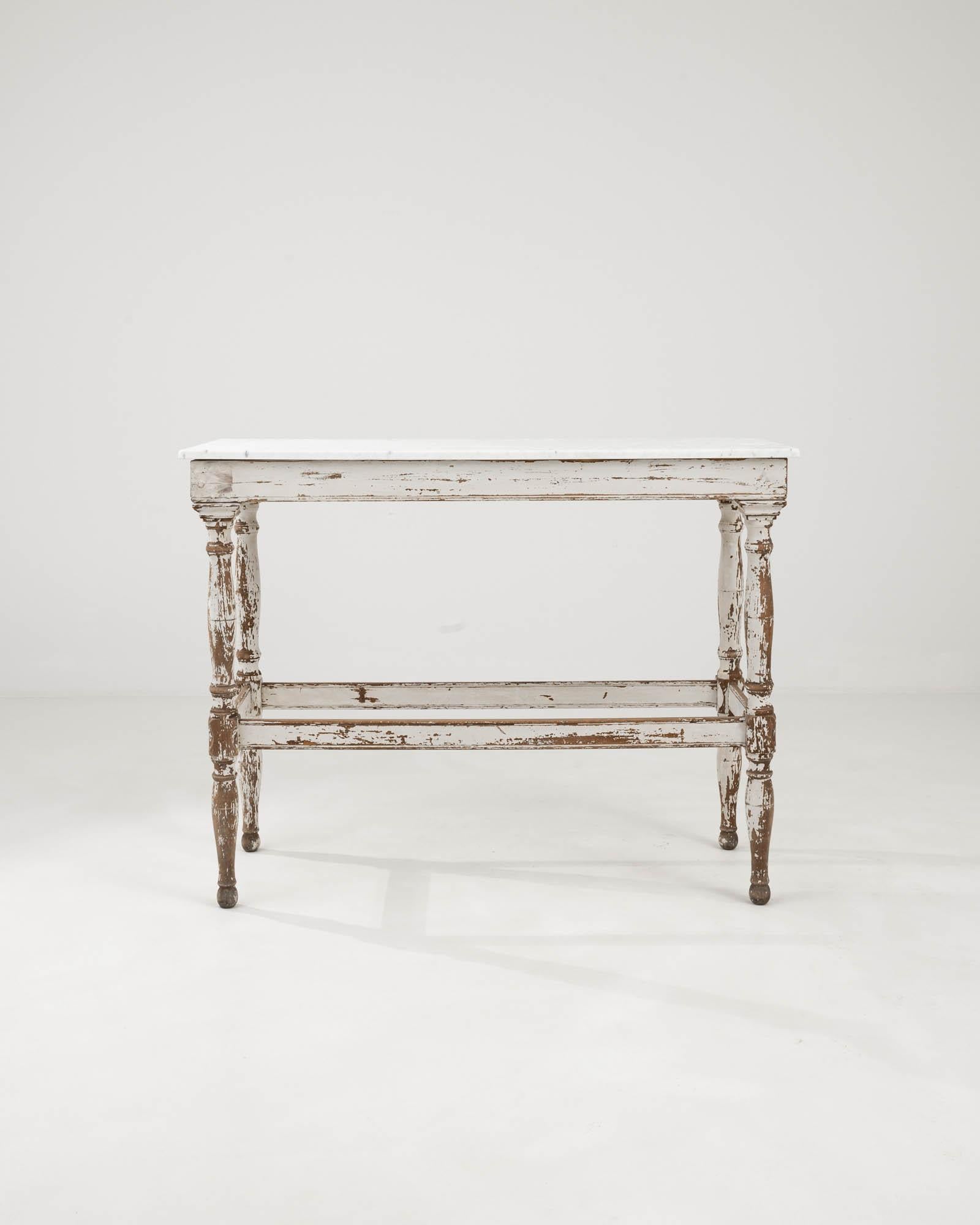 Step back in time with this exquisite 1900s French Wooden Console Table, a true gem for antique lovers and connoisseurs of timeless style. Its robust wooden frame boasts a history-rich, distressed finish that tells a tale of a century gone by, while