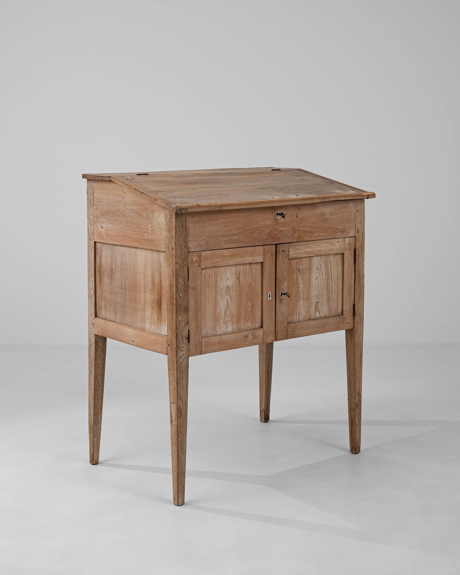 Step back into the quaint charm of the 1900s with this authentic French wooden desk. With its warm, honeyed patina, this piece carries the rich glow of history within its solid, time-honed timber. The desk's design boasts a straightforward,