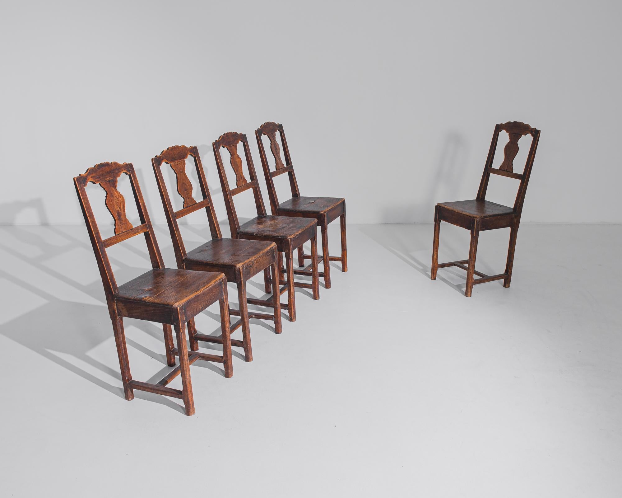 Transporting us to the refined dining rooms of 20th-century France, this set of five wooden dining chairs exudes the timeless elegance and sophistication of French design. Crafted with precision and artistry, each chair boasts a sturdy wooden frame,