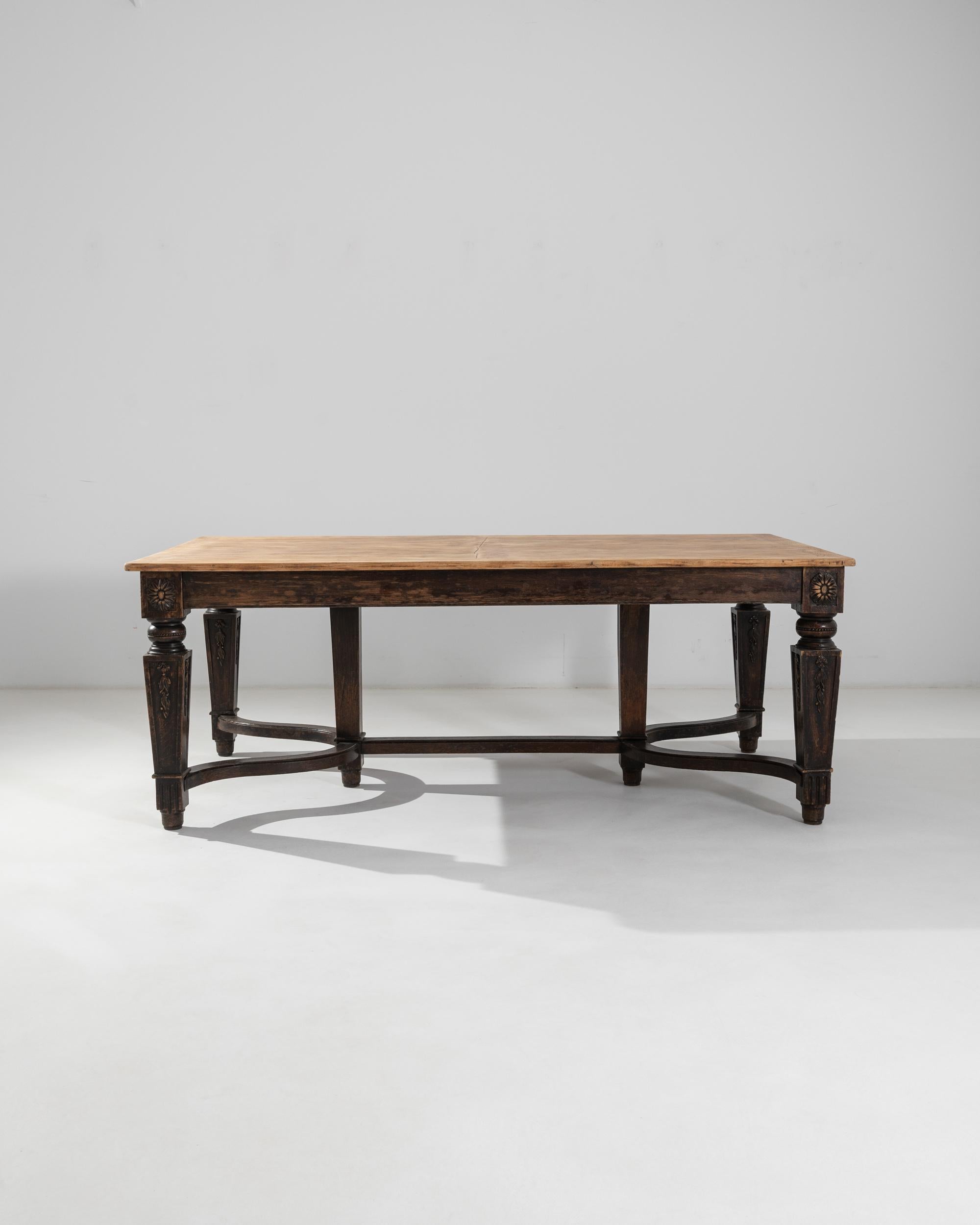 A 1900s French dining table made from oak. Hearty and expertly crafted, this expansive table emits a rich and warm glow and provides a generous tabletop to assemble a feast. The understructure of this table is composed of gracefully curved supports