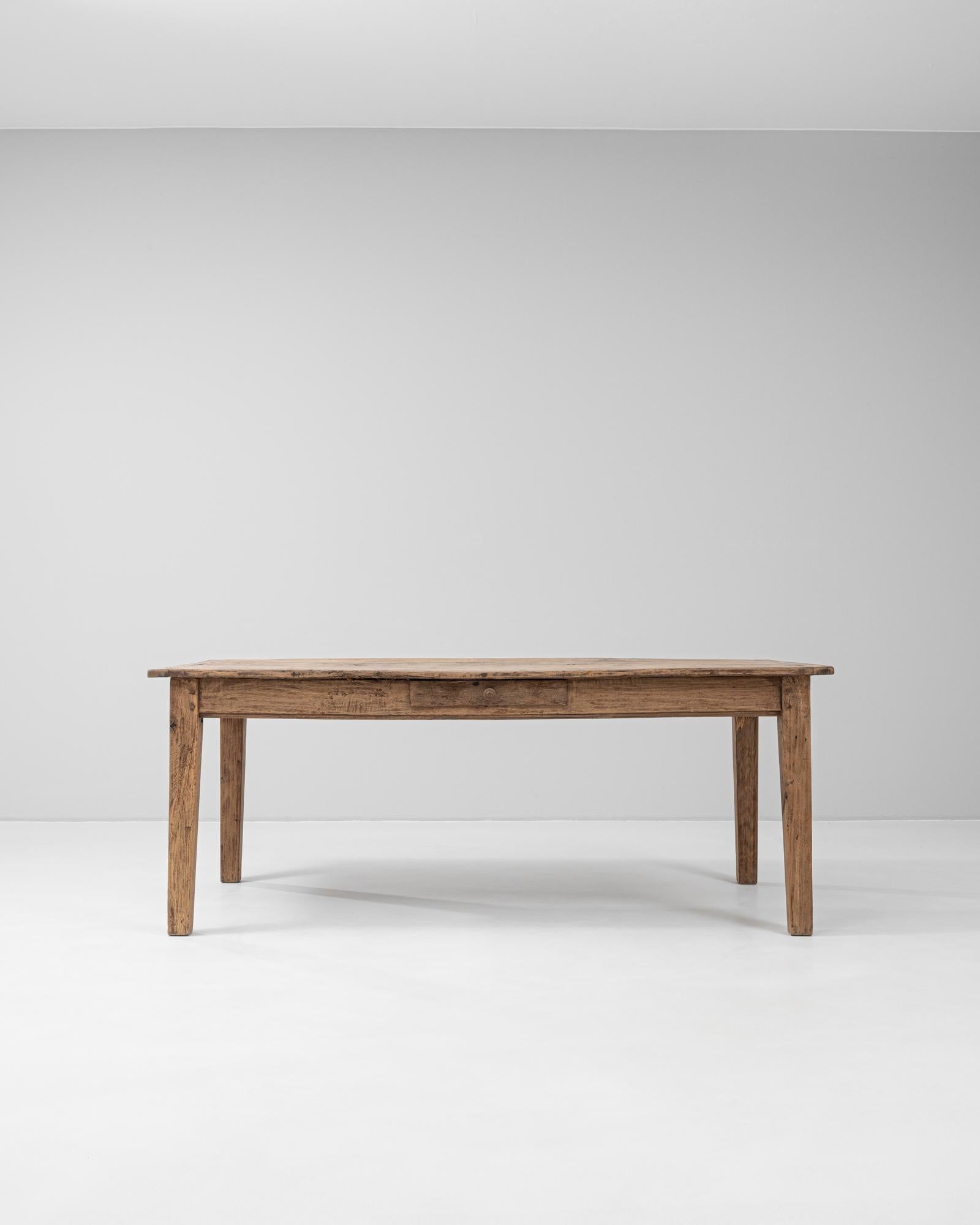 Cette table de salle à manger en bois français des années 1900 illustre la simplicité intemporelle du design provincial. Elle est fabriquée en bois massif et présente une riche patine naturelle qui témoigne de son ancienneté et de son authenticité.