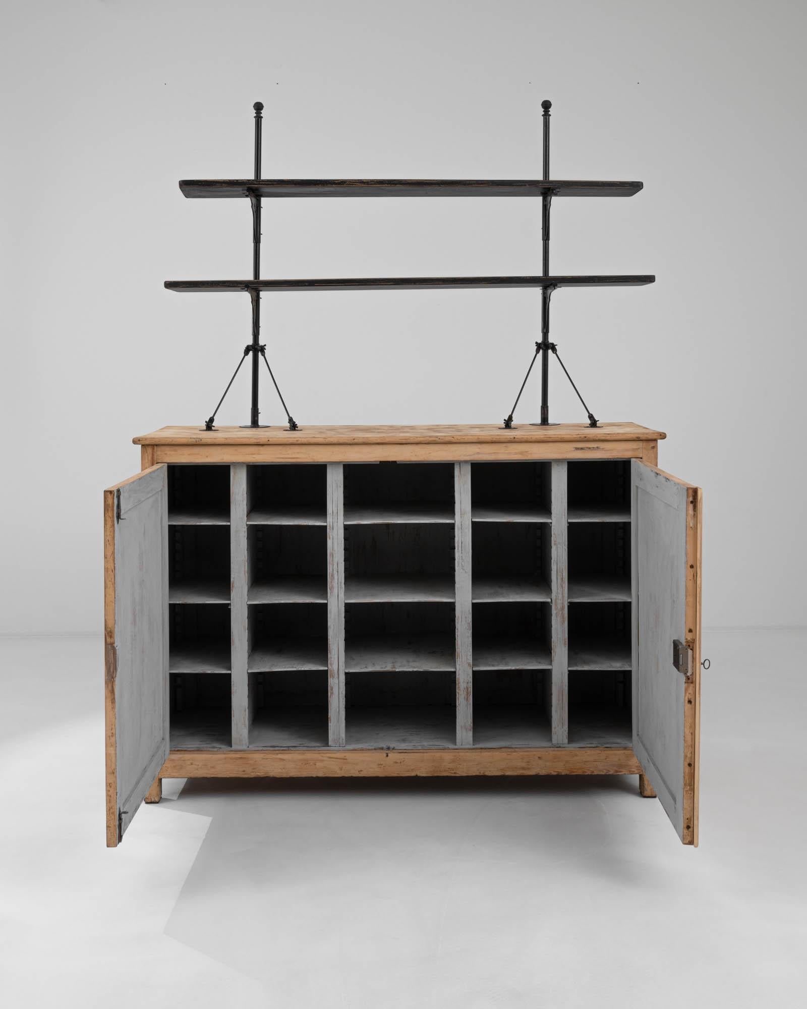 A wooden display cabinet from France, produced circa 1900. This humble country cabinet is an unexpected totem of the 20th Century: iron and wood, joined together by industry, rising towards the heavens as part of man’s march of progress: two tiers