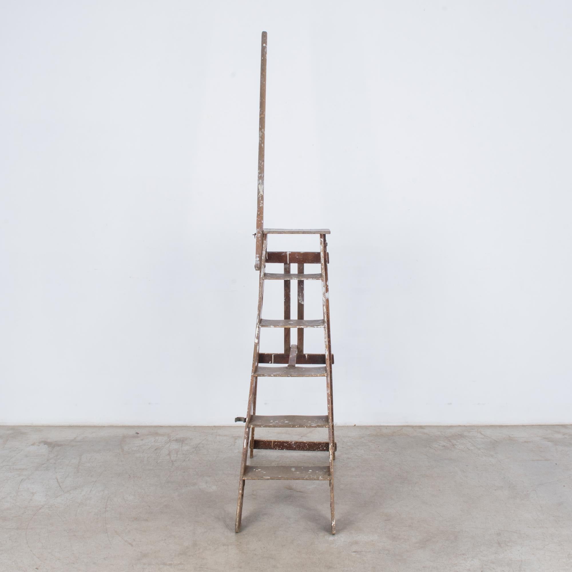This wooden step ladder was made in France, circa 1900. It features quatrefoil cutouts on the side rails and a long grab pole that can be extended for stability when standing on the upper rungs. The ladder is foldable for easy storage, and white