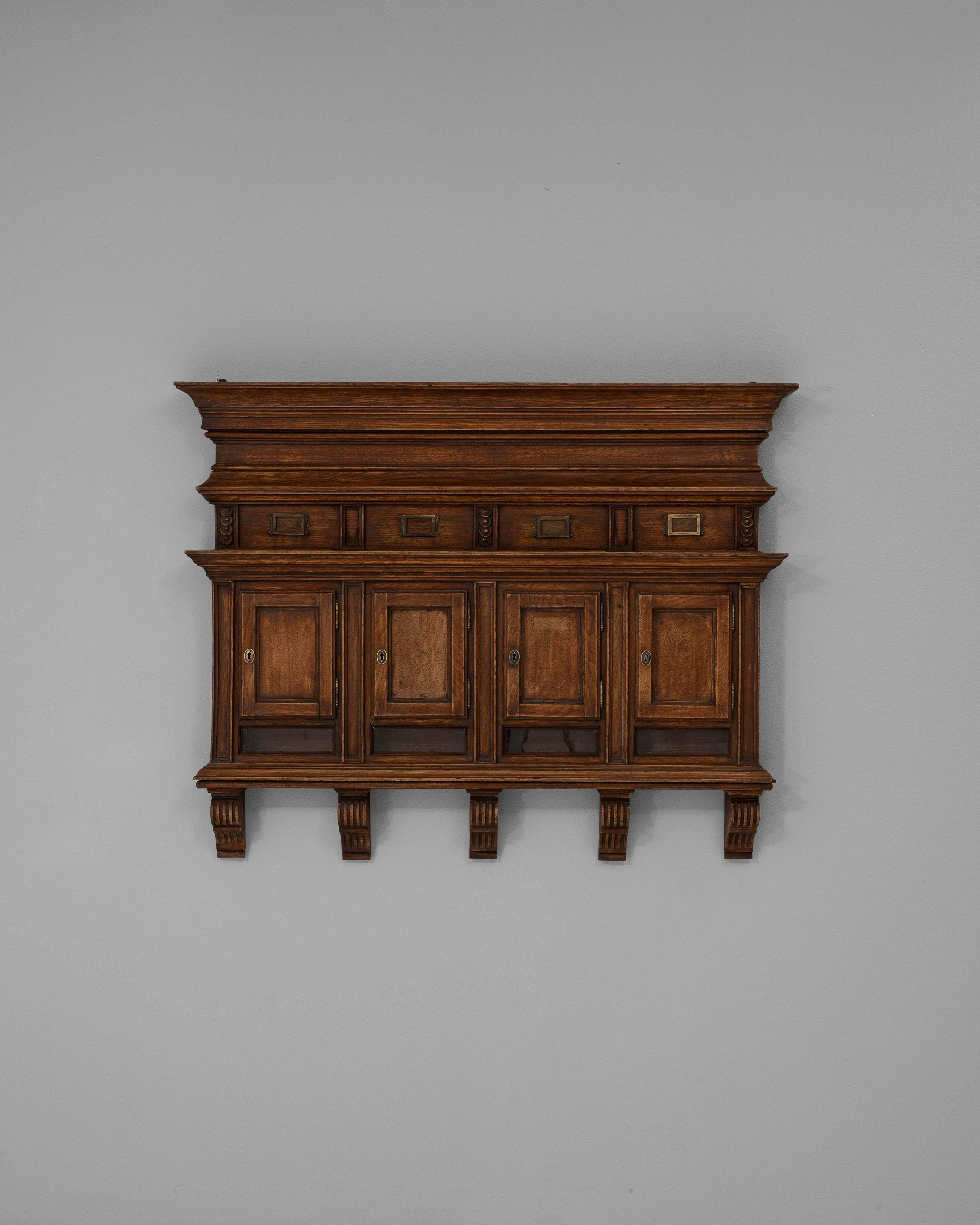 Questa cassetta delle lettere francese del 1900, originariamente progettata per l'uso in appartamento, riflette la raffinata utilità e i dettagli architettonici del design dei primi anni del XX secolo. Realizzato in legno dai toni intensi, il pezzo