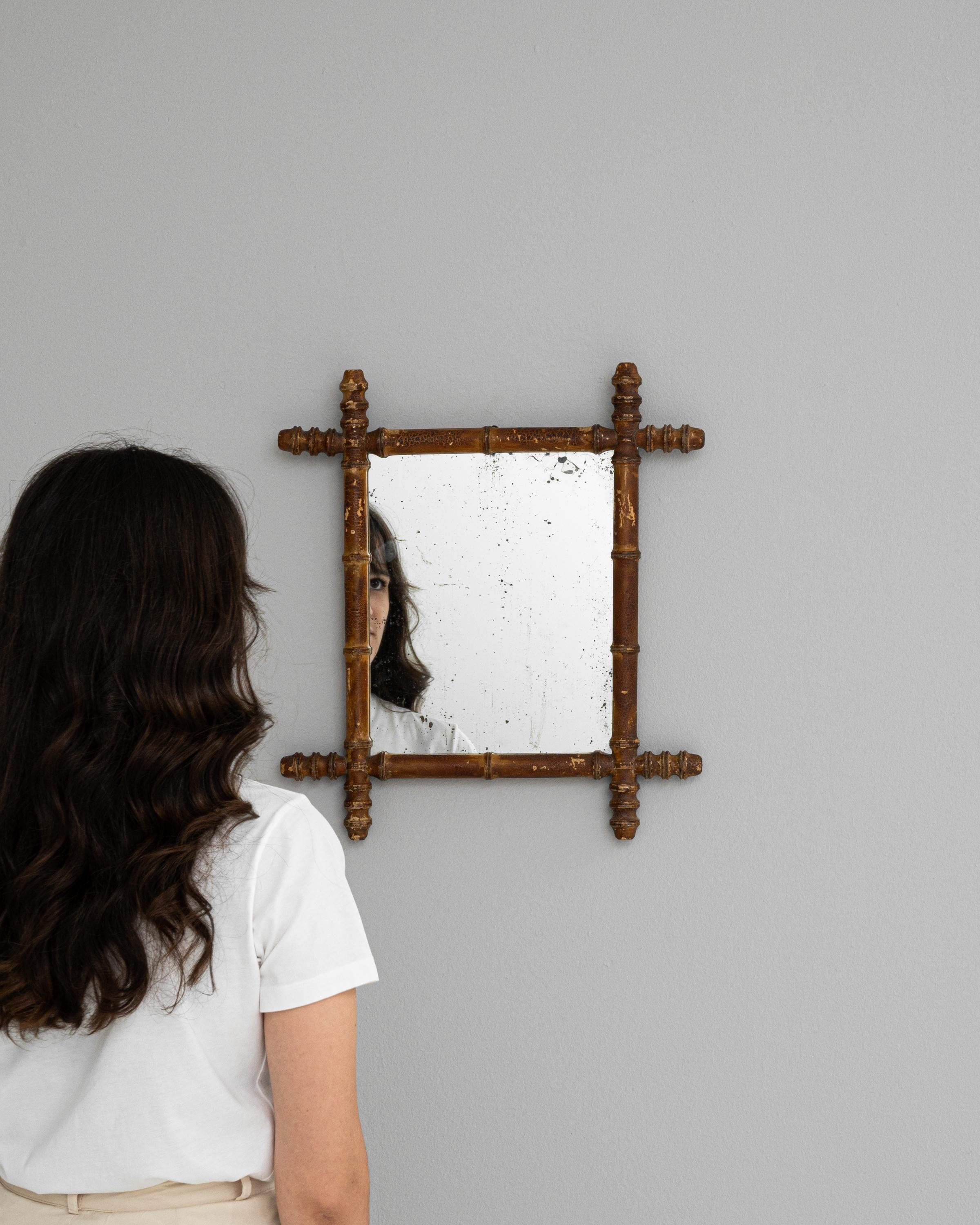 Dieser französische Holzspiegel aus der Zeit um 1900 verleiht jedem Raum einen unverwechselbaren Hauch von rustikaler Raffinesse. Sein Charakter wird durch eine warme, honigfarbene Patina unterstrichen, während die gedrechselten, spindelförmigen