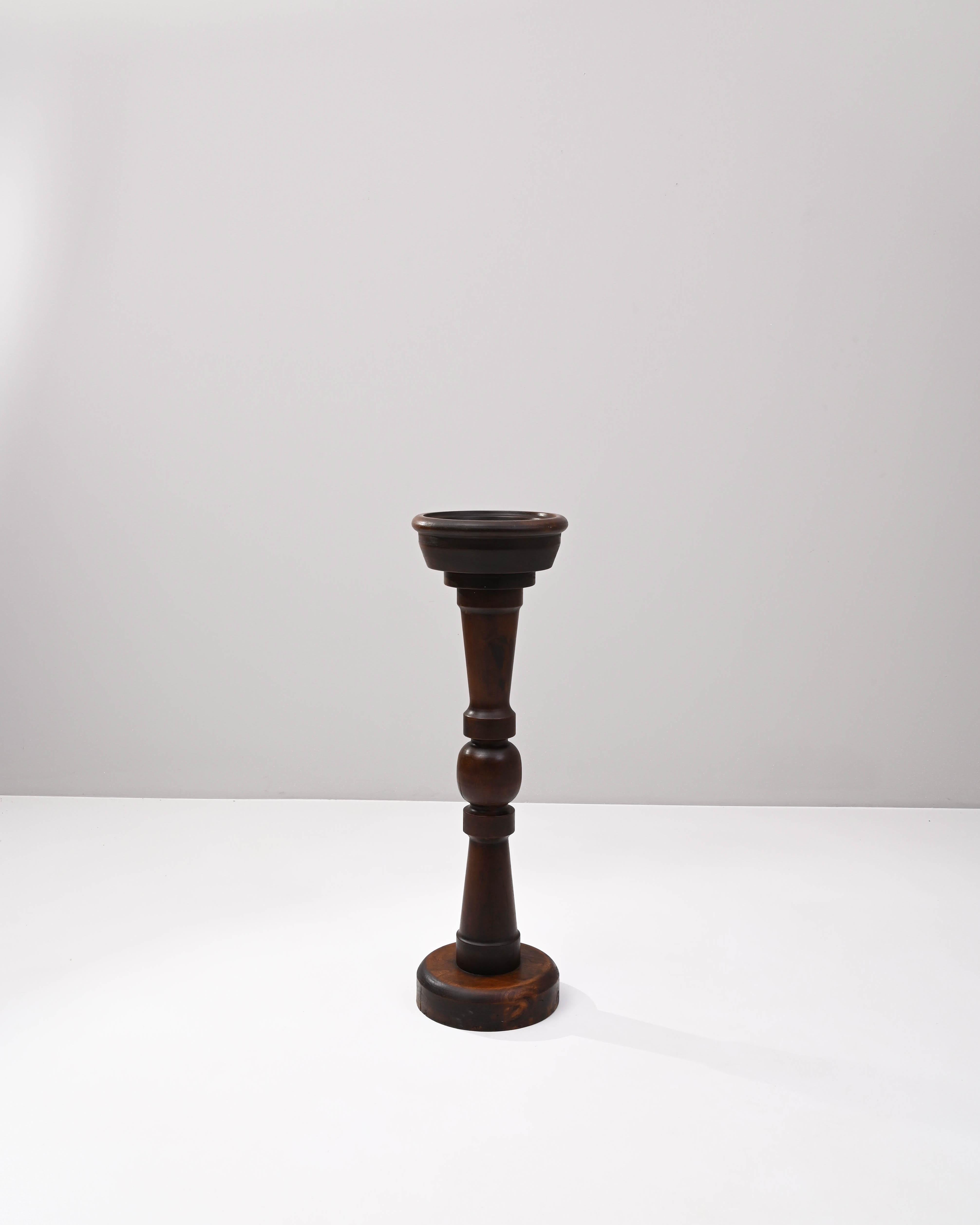 Lathed and polished mahogany, this elegant wooden post hails from early 20th Century France. A vide-poche or other repository, the pedestal base supports an integrated wooden bowl – certainly purpose built– once used as a vessel for a convenient