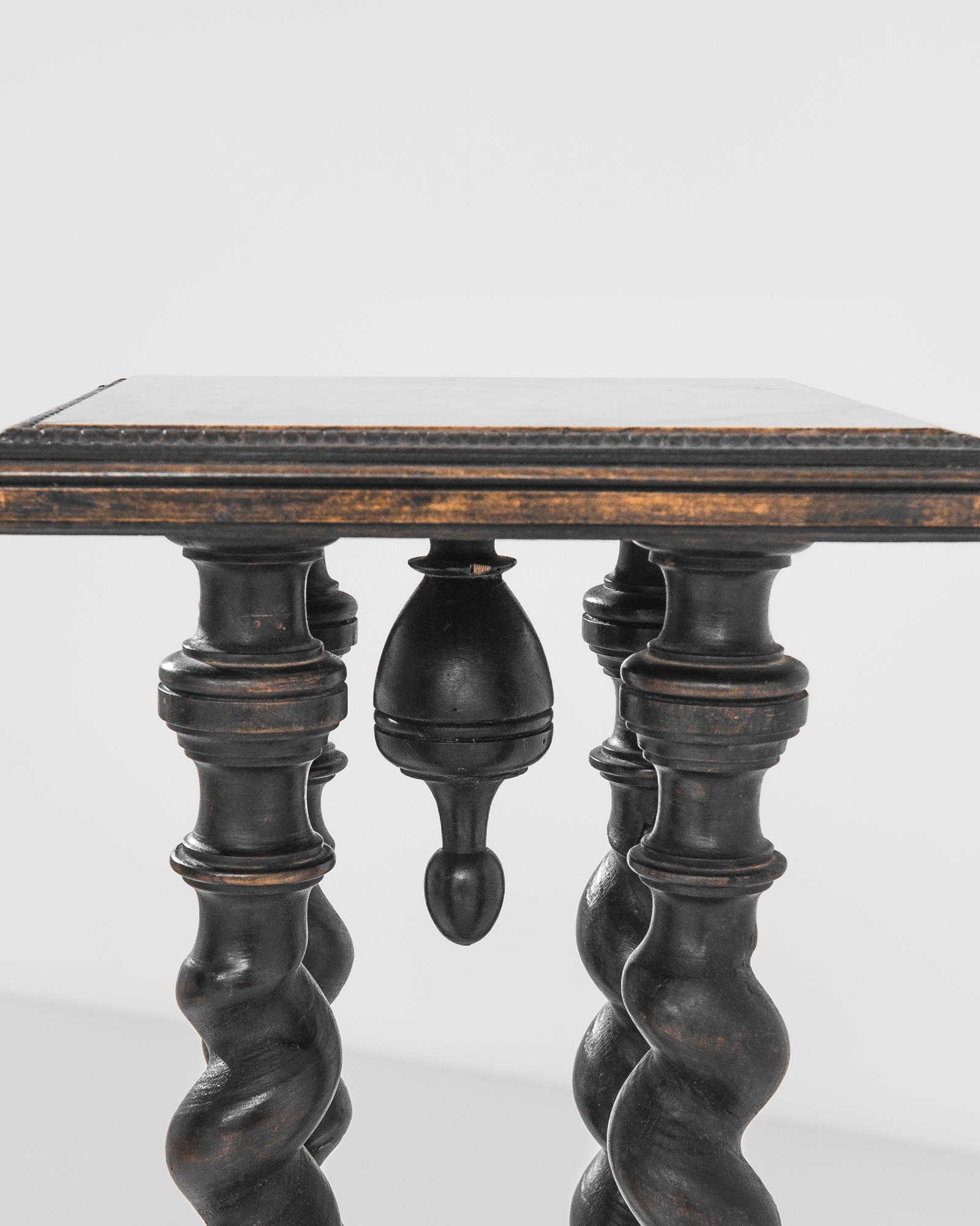 Dignified and ornate, this wooden pedestal from turn of the century France provides an eye-catching centerpiece. Four barley twist columns support a square platform, crowned with a marble tabletop. The pale coral color of the marble, veined with