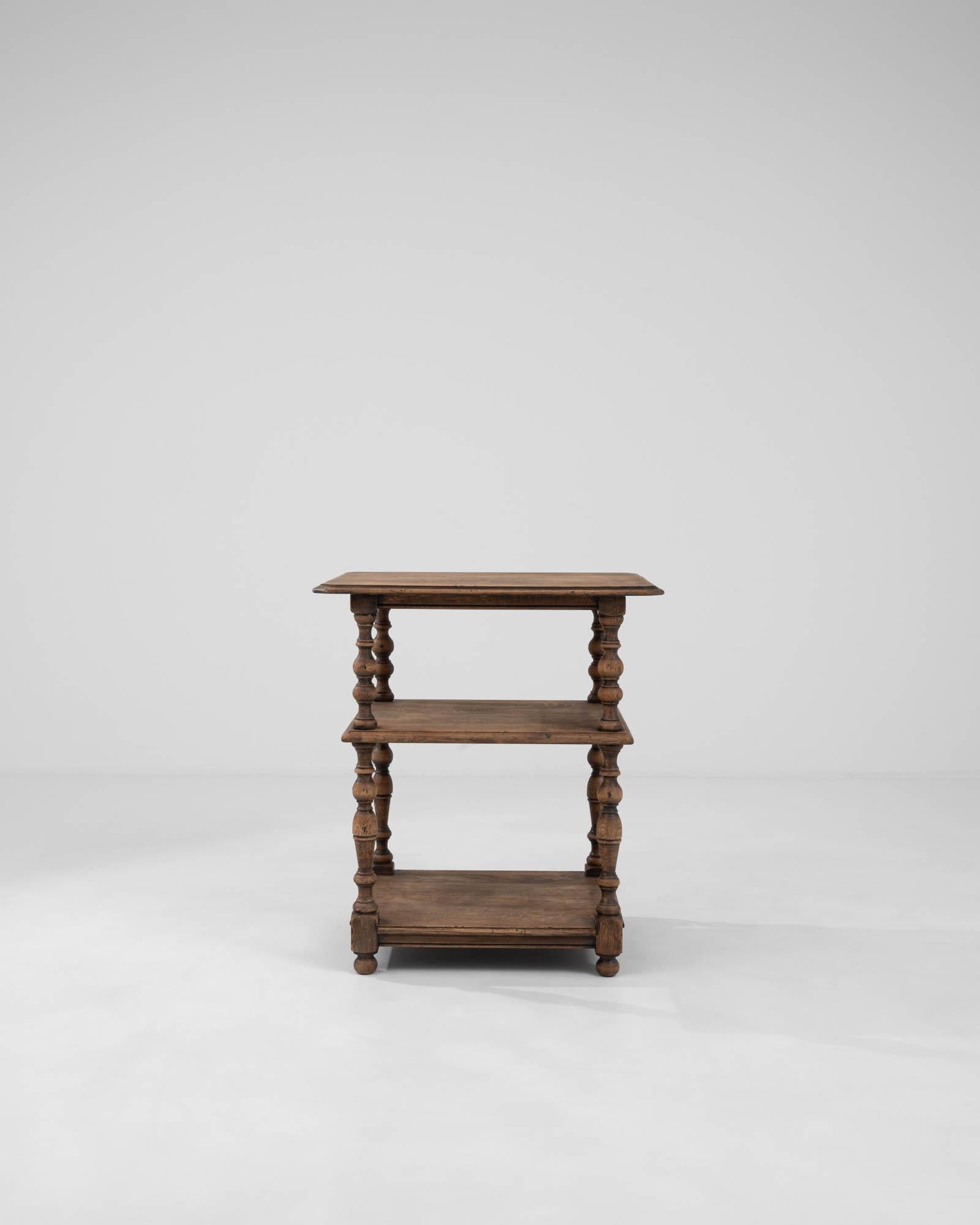 Step back in time with this charming 1900s French wooden side table, a piece that epitomizes the grace and functionality of early twentieth-century craftsmanship. This delightful table boasts a trio of tiers, each connected by elegantly turned