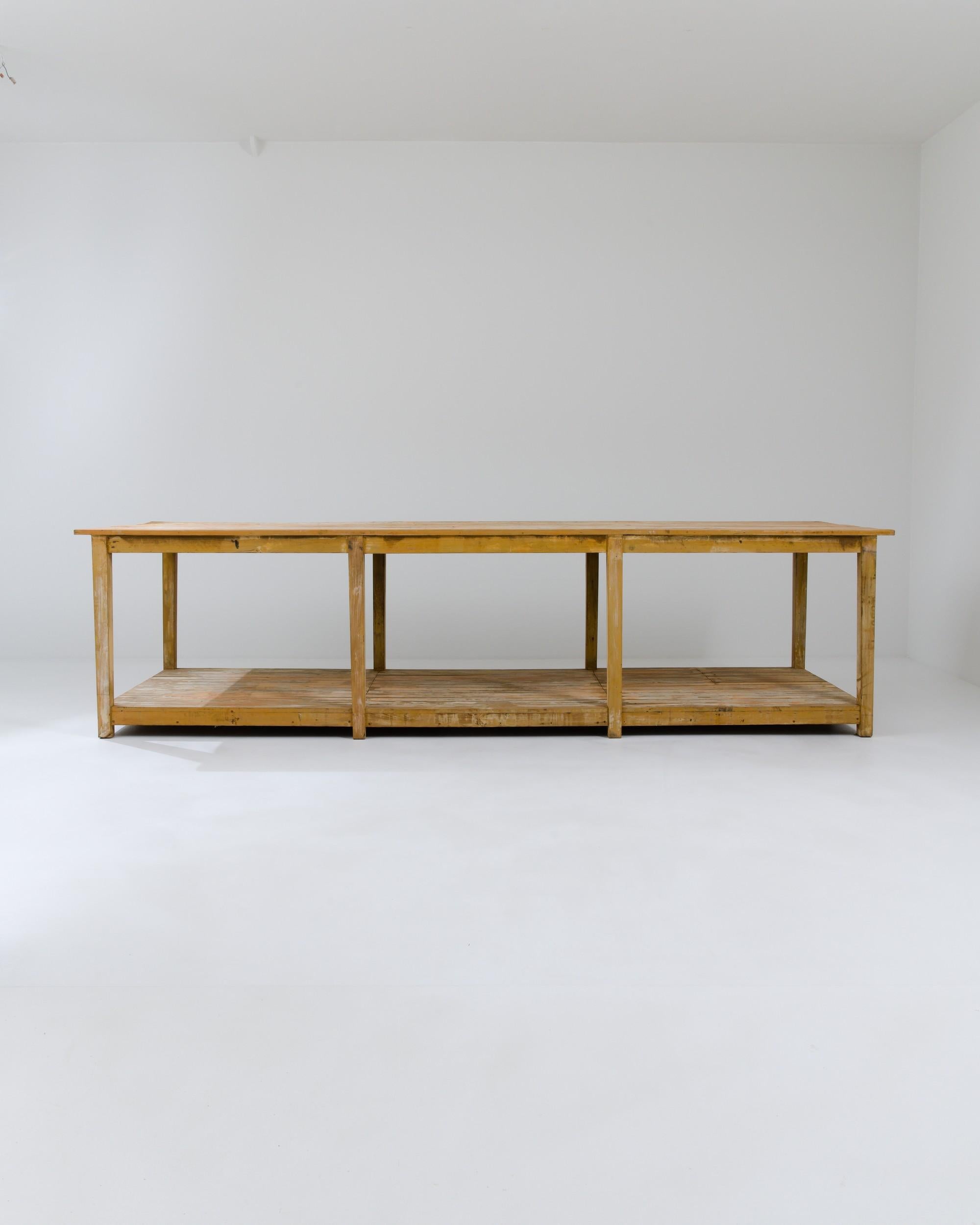 Ein Holztisch, der um 1900 in Frankreich hergestellt wurde. Dieser lange und ausladende Tisch hat einen rustikalen Charme und bietet eine große Fläche. Im Laufe der Zeit ist das Holz stark patiniert, vor allem im oberen und unteren Bereich des