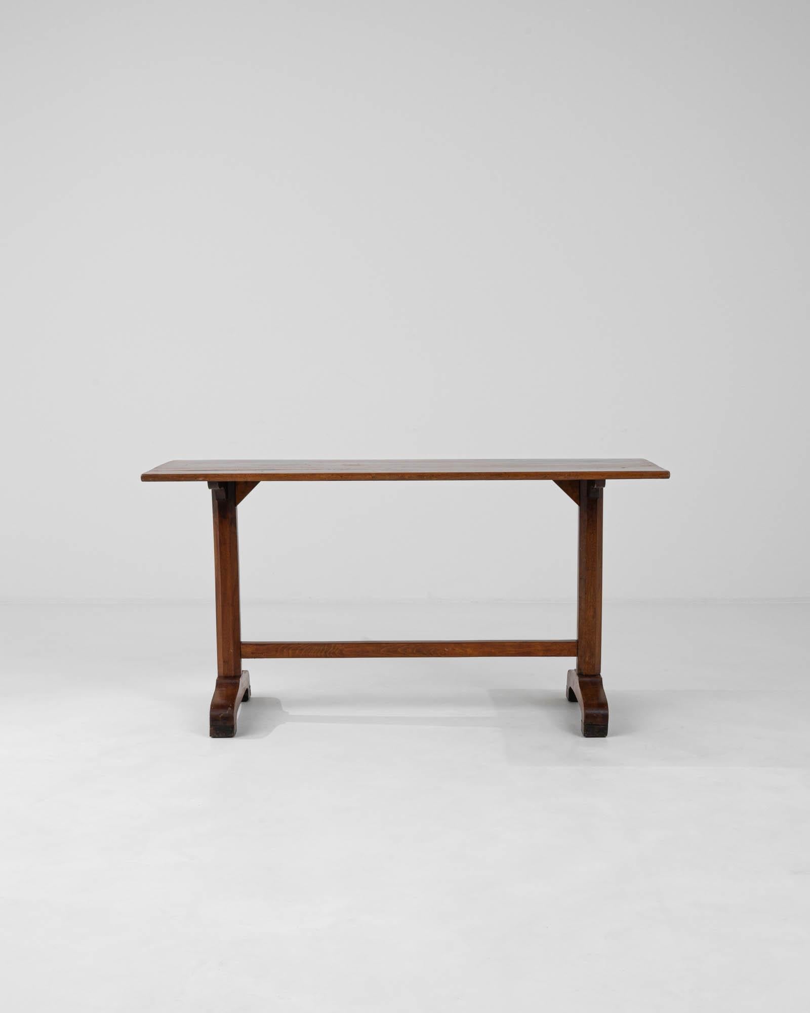 Cette exquise table française en bois des années 1900 est un magnifique artefact de son époque, rayonnant de l'essence de l'artisanat classique. La table, structurée en bois riche aux teintes chaudes, porte une patine qui raconte son histoire