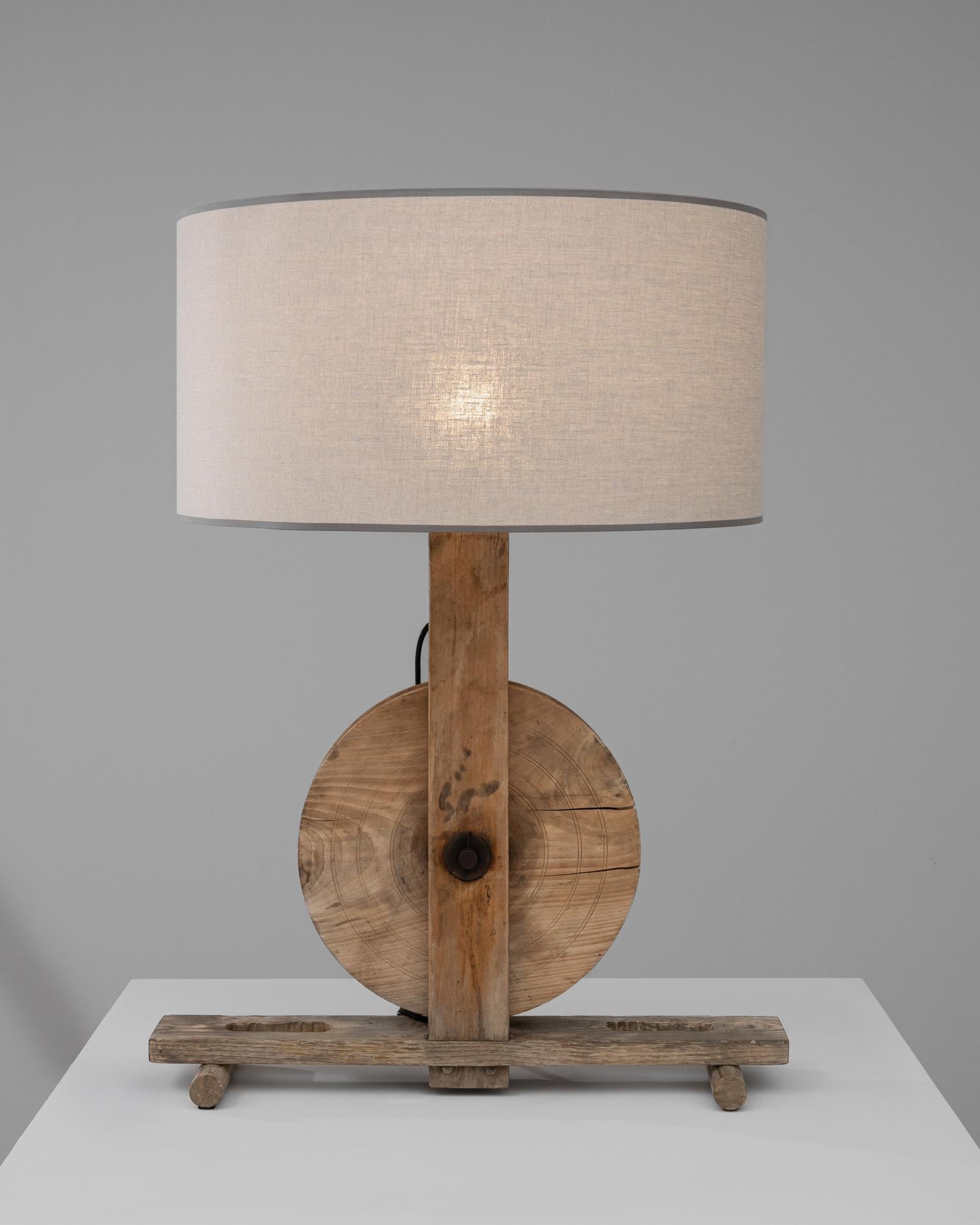Infusez votre espace de vie avec le charme rustique de cette lampe de table britannique unique du début du 20e siècle, où la fonctionnalité rencontre l'artisanat. Le socle, sculpté dans du bois vieilli dont tous les nœuds et grains naturels sont