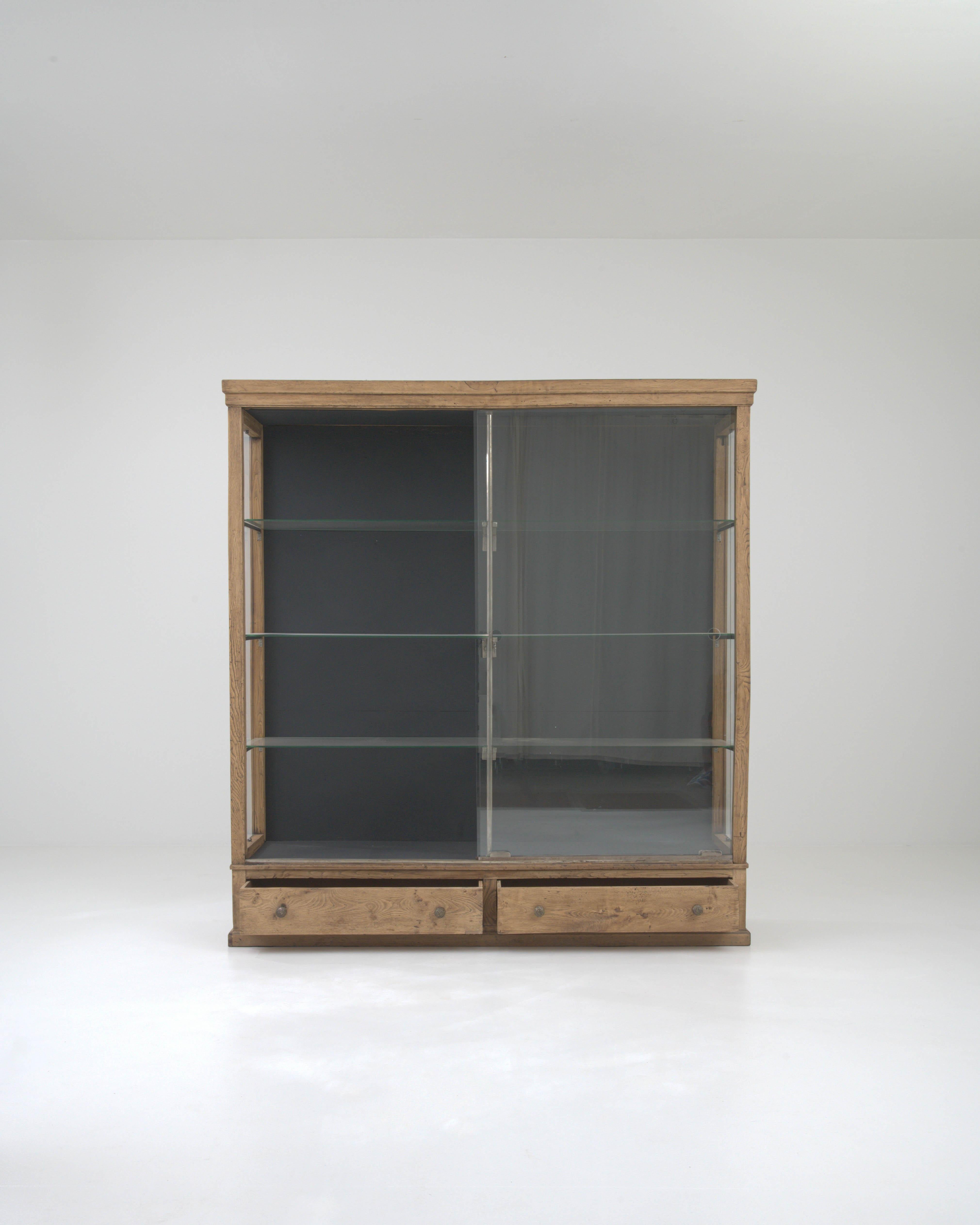 Discover the timeless elegance of the early 1900s with this exquisite French Wooden Vitrine. Crafted with the utmost care, this display cabinet exudes a sense of history and refinement, perfect for the discerning collector or interior design
