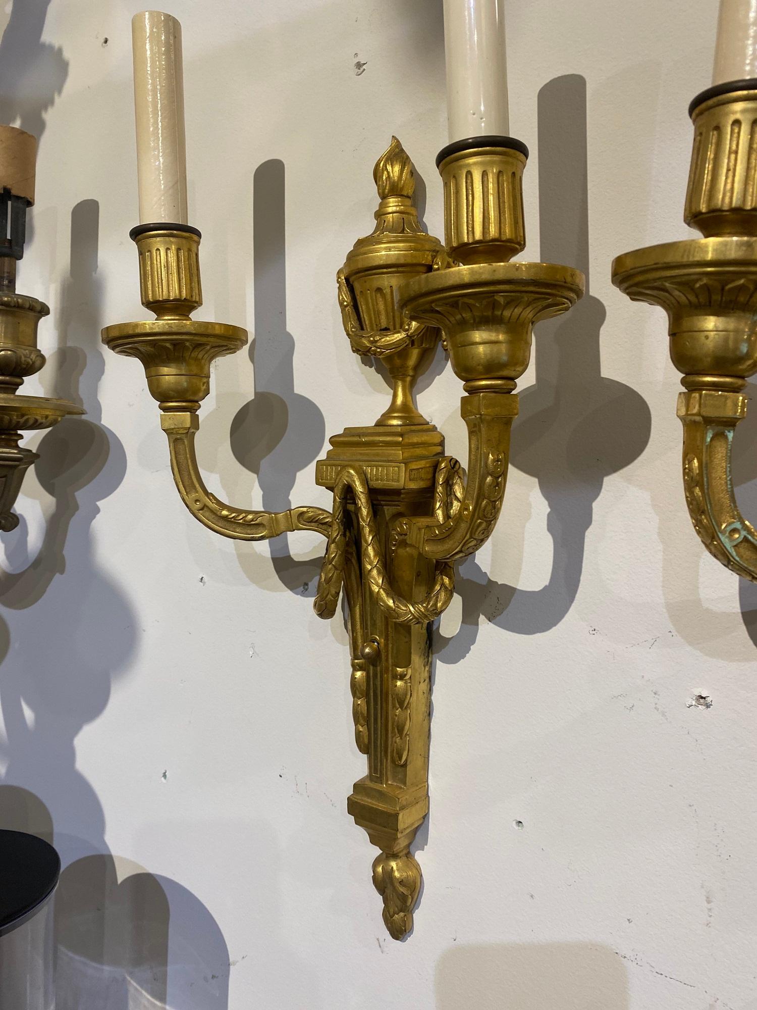 Pair of circa 1900’s Caldwell gilt bronze sconces with two lights. Original finish and patina