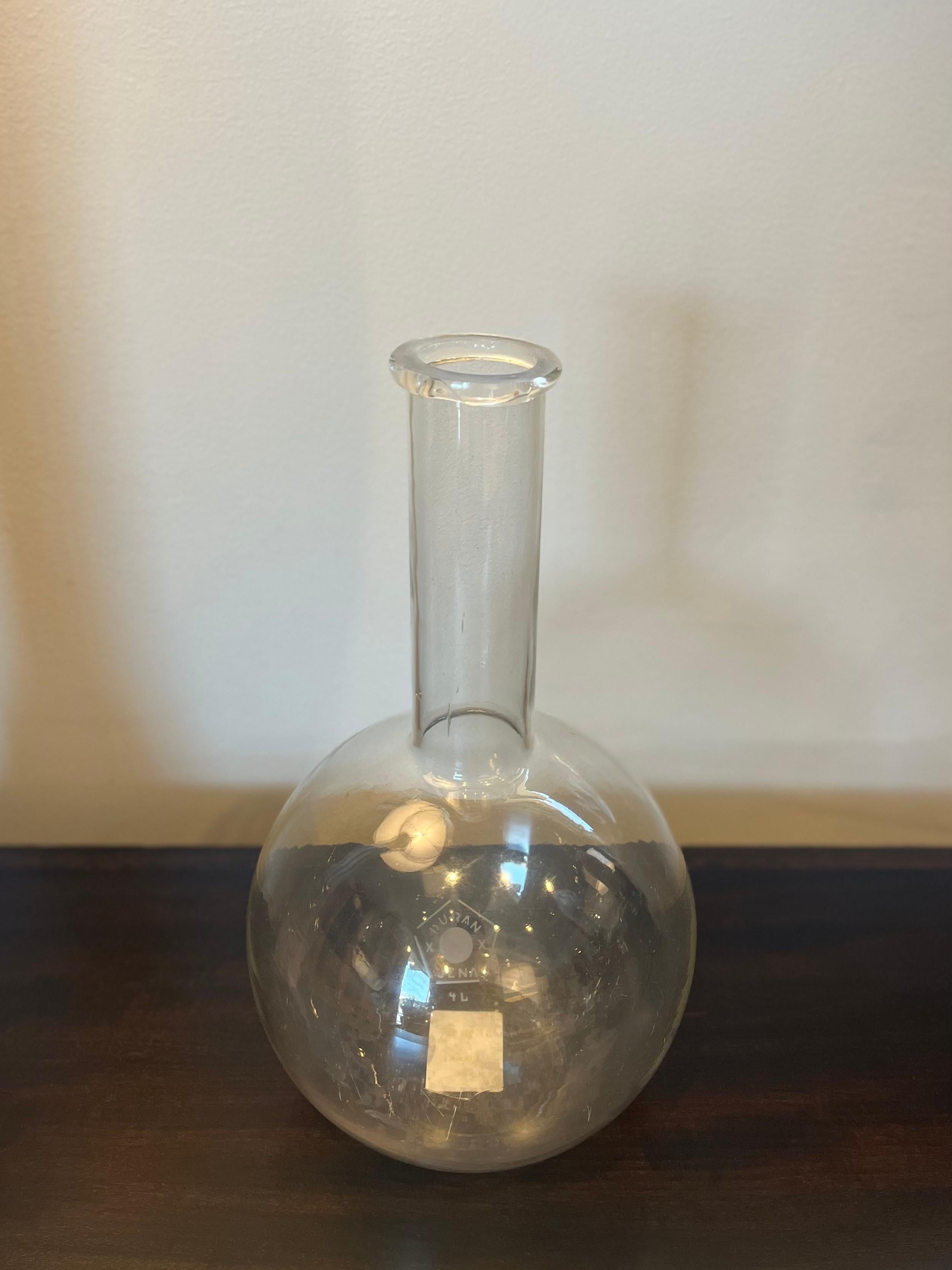 Glass chemist's beaker from 1900s France. With a spherical body and long cylindrical bottle neck, the vessel has a pleasingly modern shape. An excellent example of early an scientific apparatus, the piece could work as a vase or as a decorative