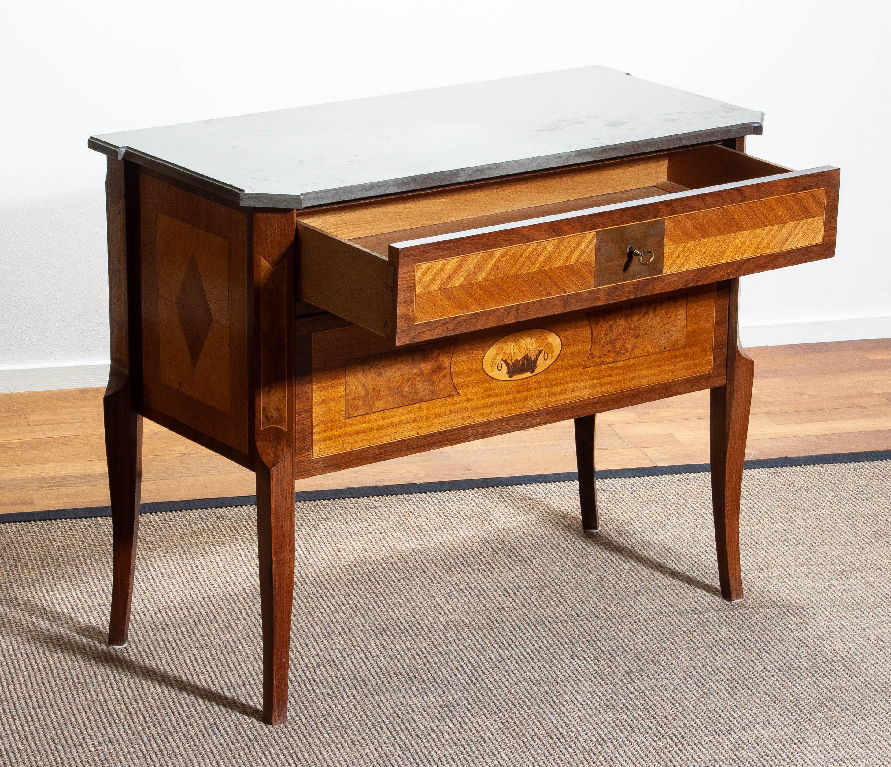 Beautiful Gustavian commode with large selection of wood craft techniques using mahogany, walnut, birch and various fruitwoods with a Kolmarden top.
Origin: Stockholm, Sweden, circa 1909.
The overall condition is good.
We ship in plywood crates!