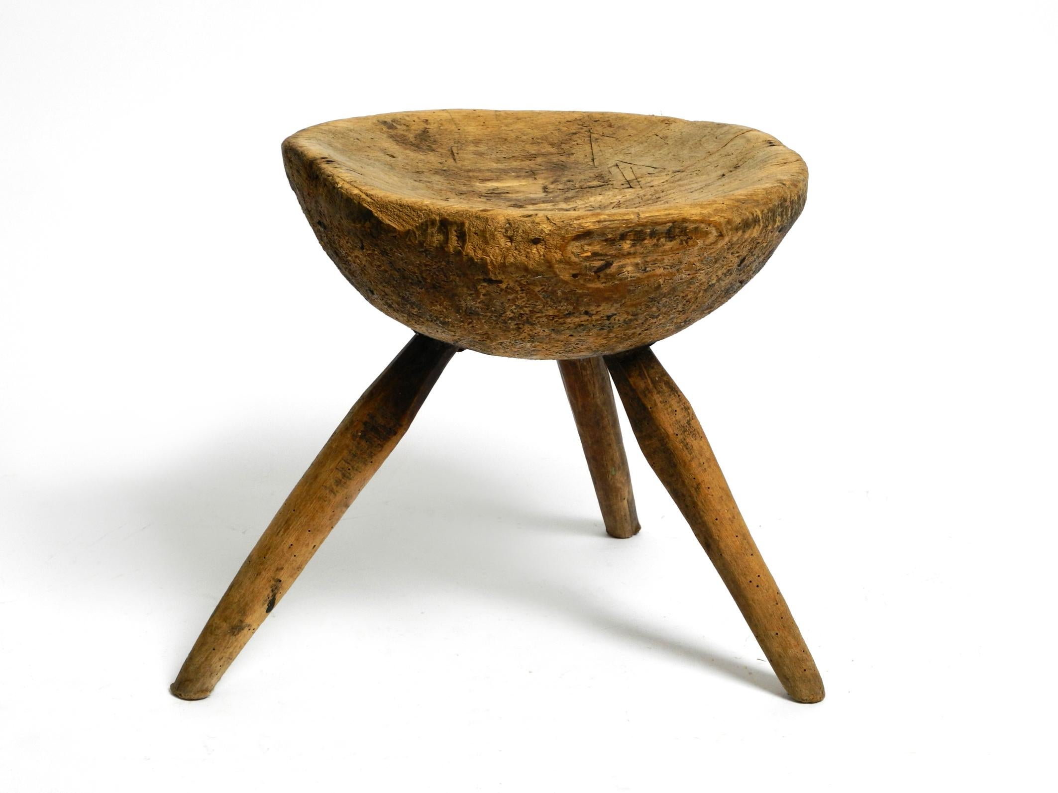 Beautiful original hand carved three legged stool or milking stool made from solid wood.
Made in Germany around 1900. Beautiful patina.
Very robust and heavily built, can also be used as a small side table.
Slightly curved seat with very old