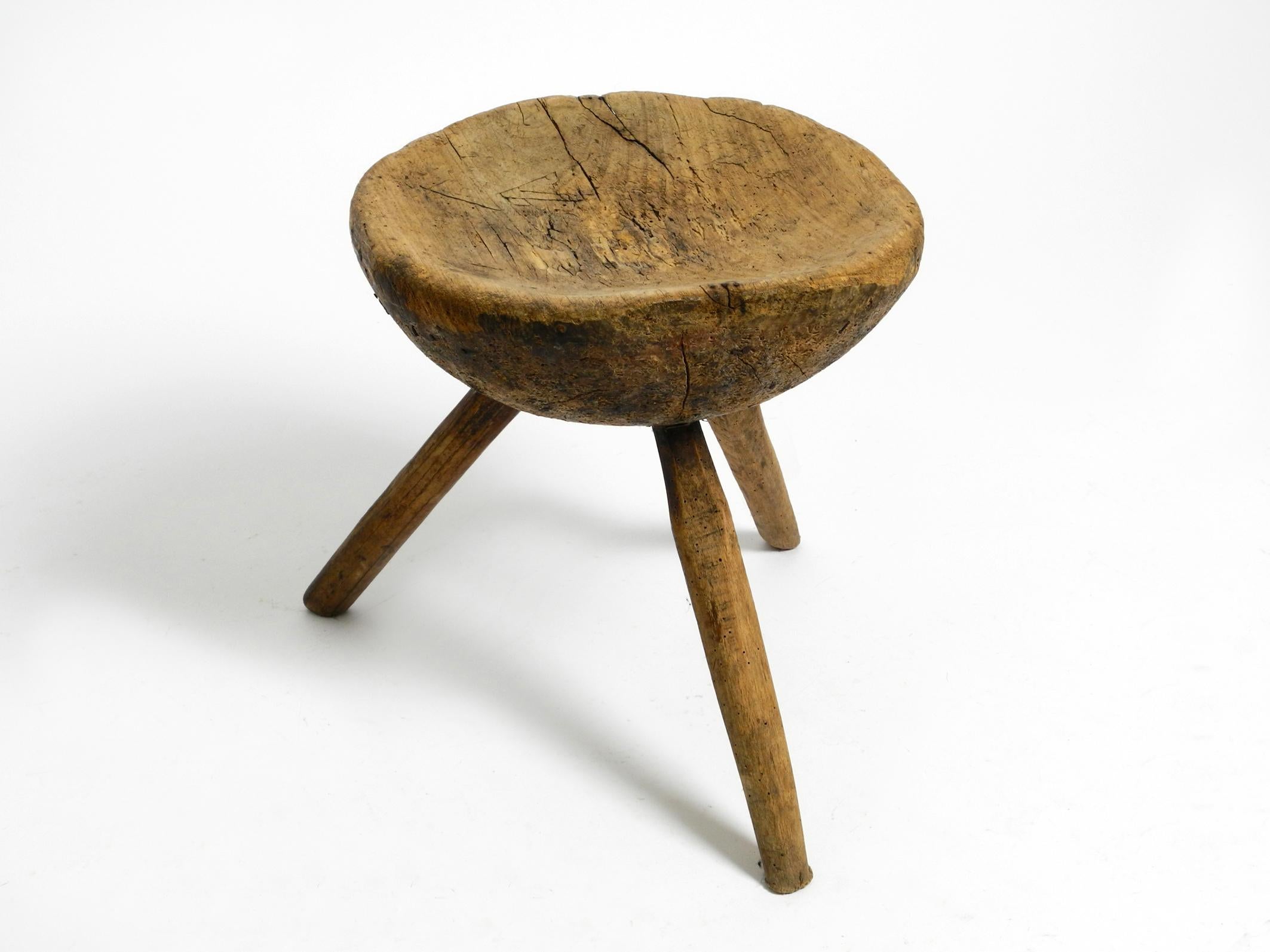 German 1900s hand-carved three-legged solid wood stool with a fantastic patina For Sale