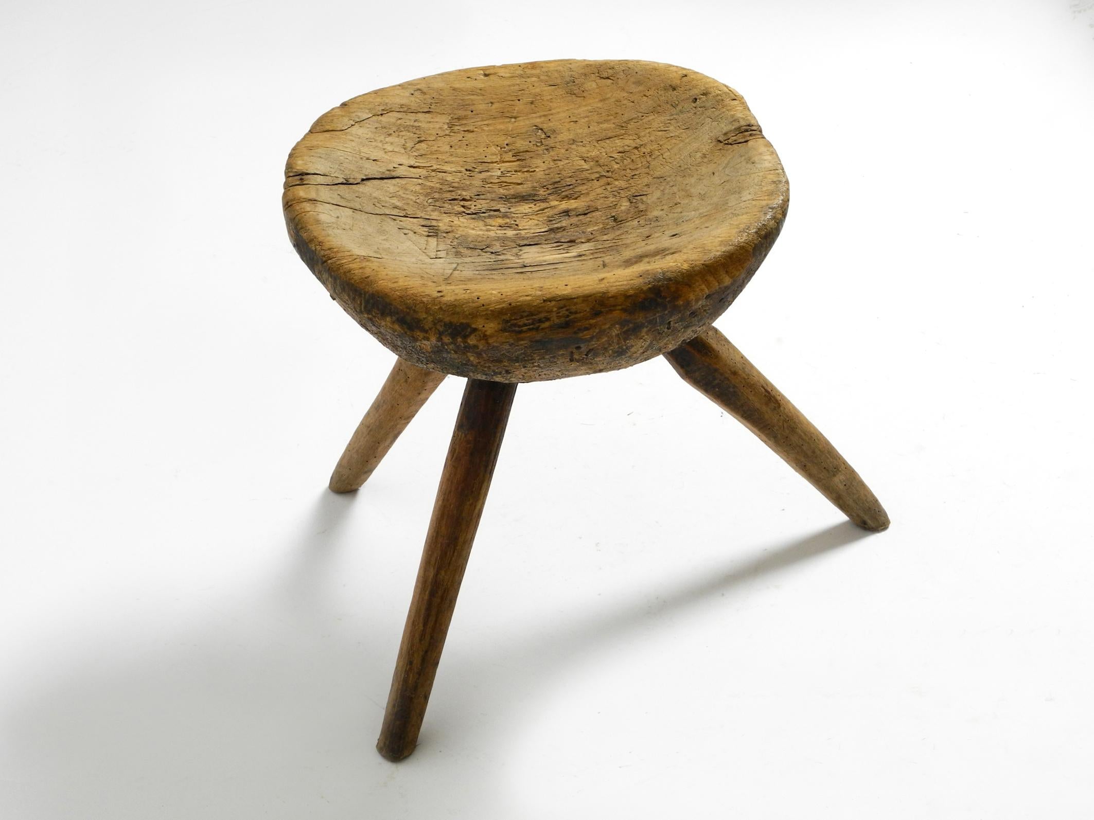 1900s hand-carved three-legged solid wood stool with a fantastic patina In Good Condition For Sale In München, DE