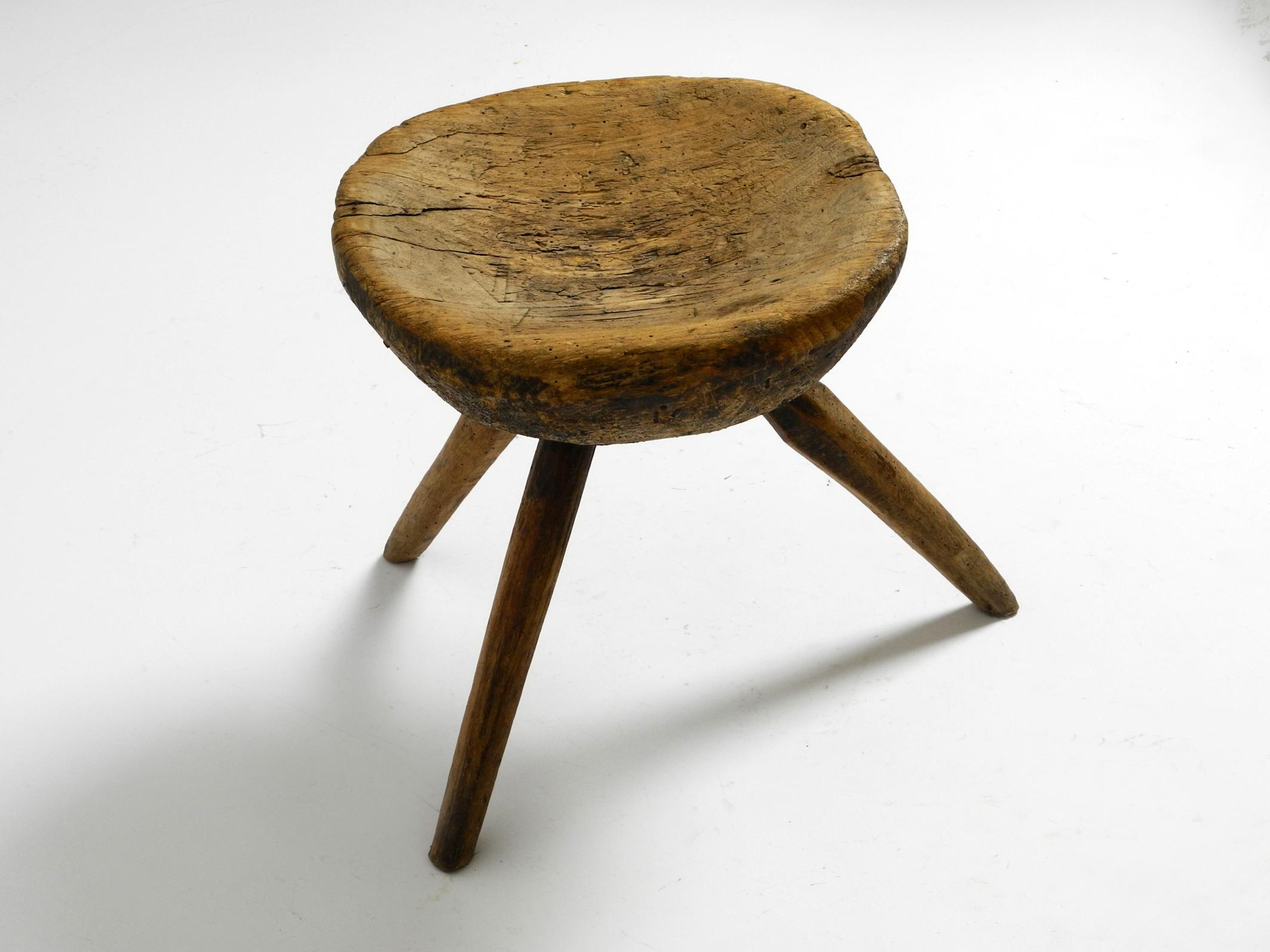 Early 20th Century 1900s hand-carved three-legged solid wood stool with a fantastic patina For Sale