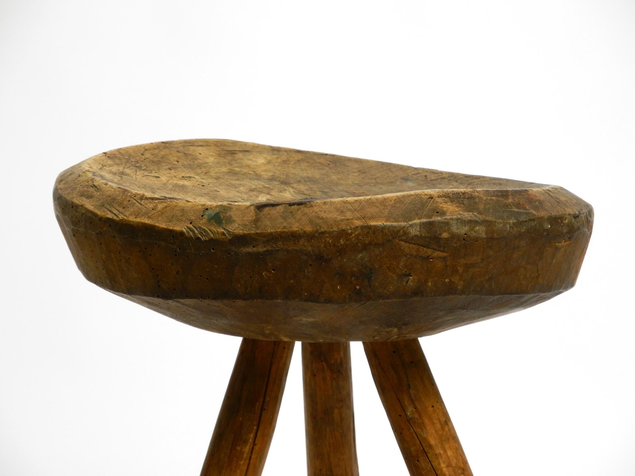 Early 20th Century 1900s hand-carved three-legged solid wood stool with a fantastic patina For Sale