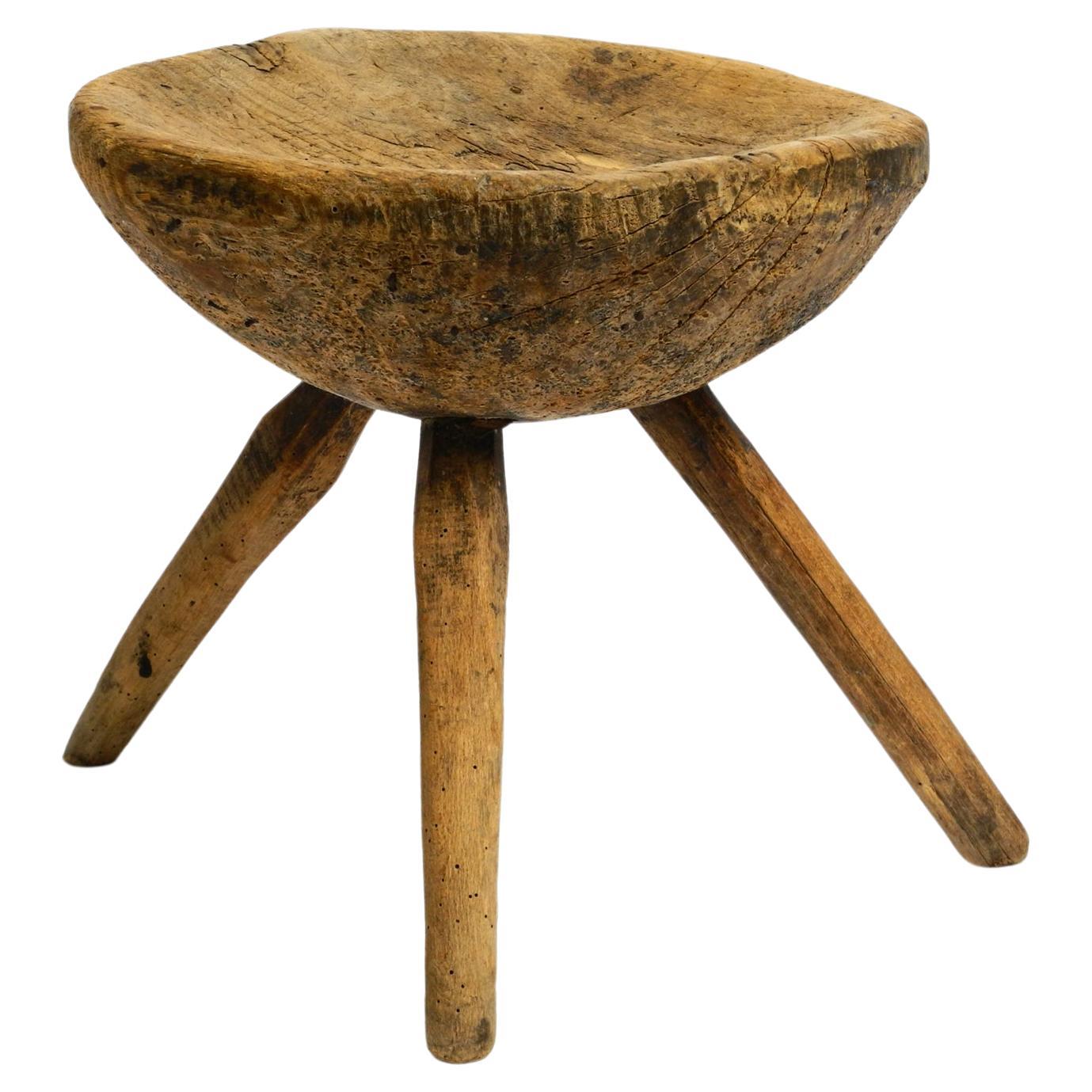 1900s hand-carved three-legged solid wood stool with a fantastic patina For Sale