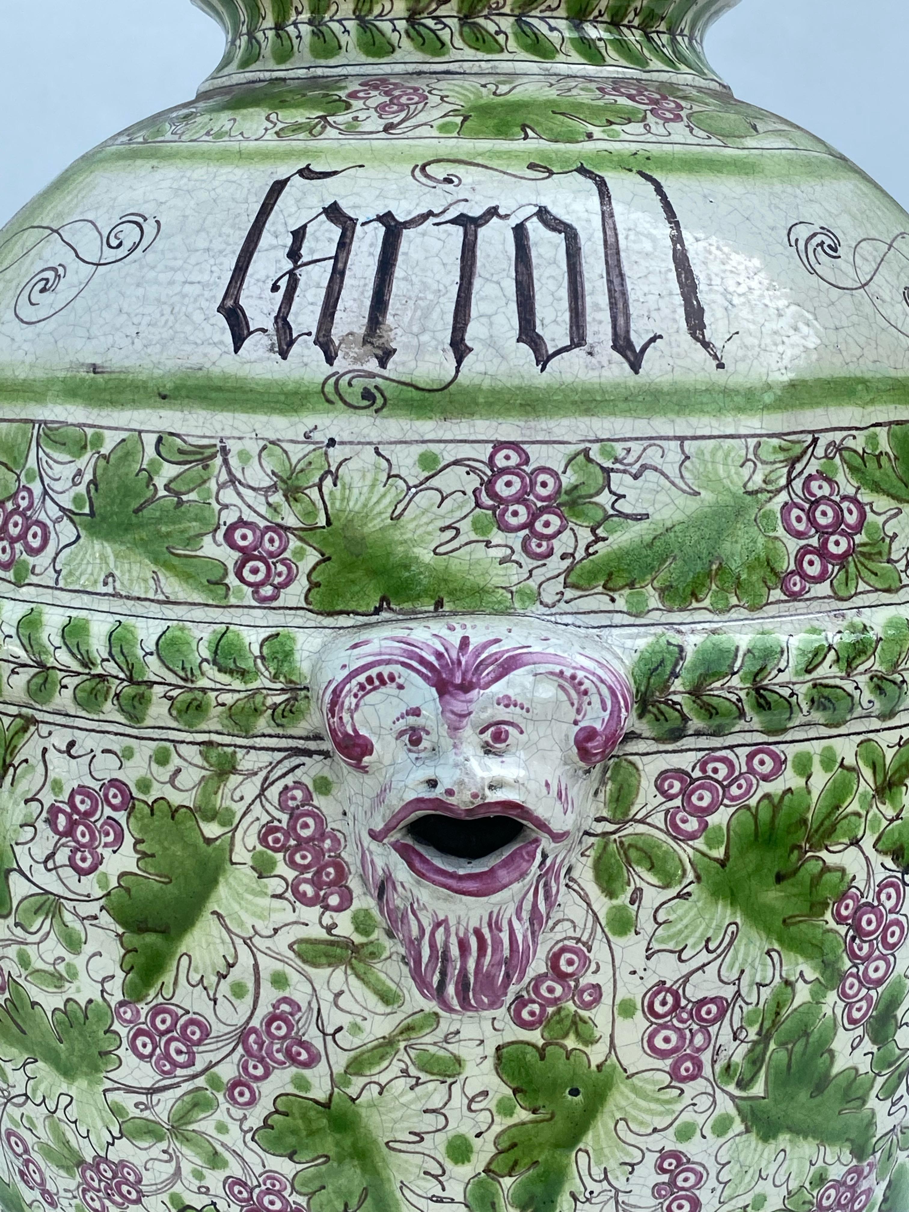 1900s Italian terracotta jars. Hand painted with leaf and grape motif. Handled. Opening of mouth is 6.5