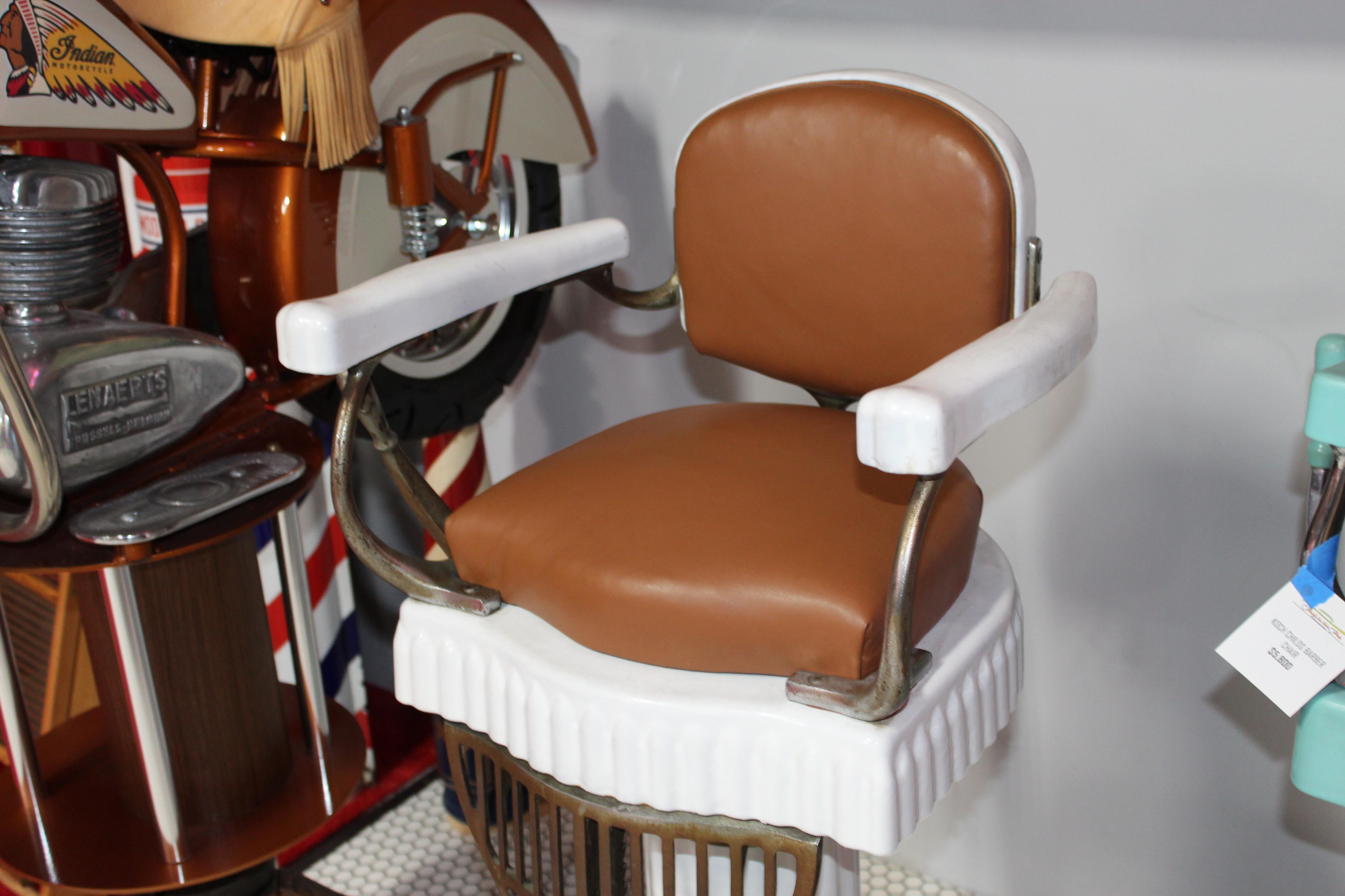 Ribbed & Flutted porcelain base. Previously semi-restored child’s barber chair. Looks like the leather was re done but the chair is still original. Porcelain shows its age / has patina look land some small nice but over all very clean chair. Koken
