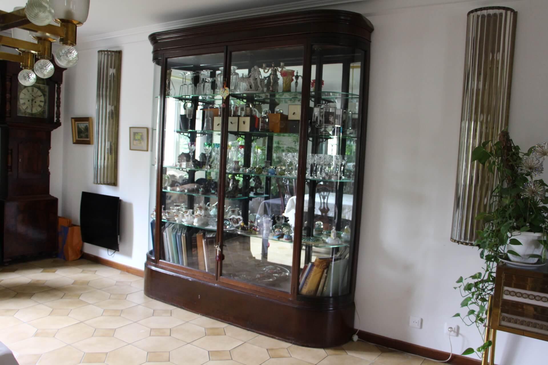 This late 19th to early 20th Century bow fronted shop display cabinet with double doors, and four adjustable internal shelves over a plinth base, is really spectacular. Its glass shelves rest on cast iron adjustable brackets . Its glass shelves and