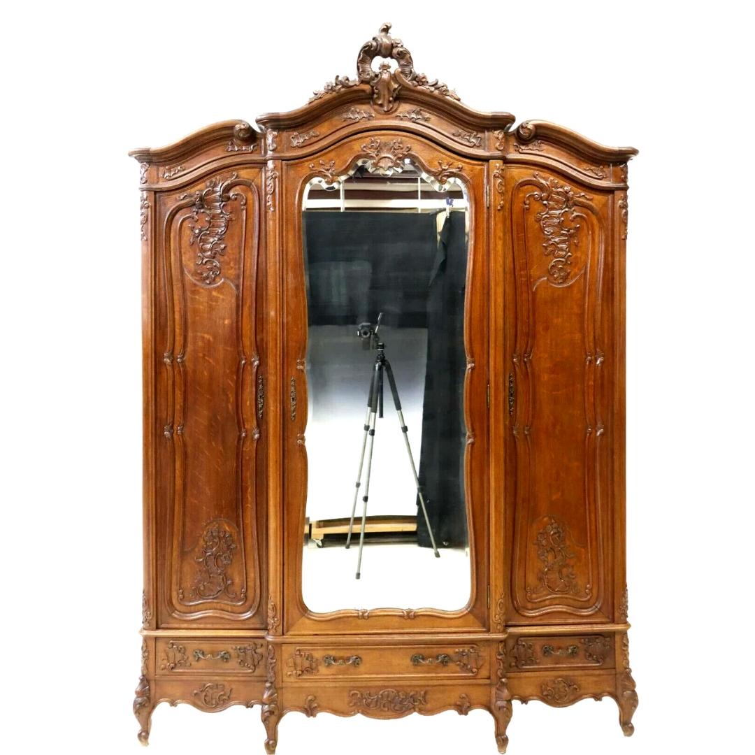 Gorgeous armoire, triple, Louis XV style breakfront, mirrored, crest, 3 drawers, early 1900s, 20th century! Great for storing clothing in the bedrooms! 

Louis XV style oak breakfront armoire, late 19th/ early 20th century, carved rocaille crest,
