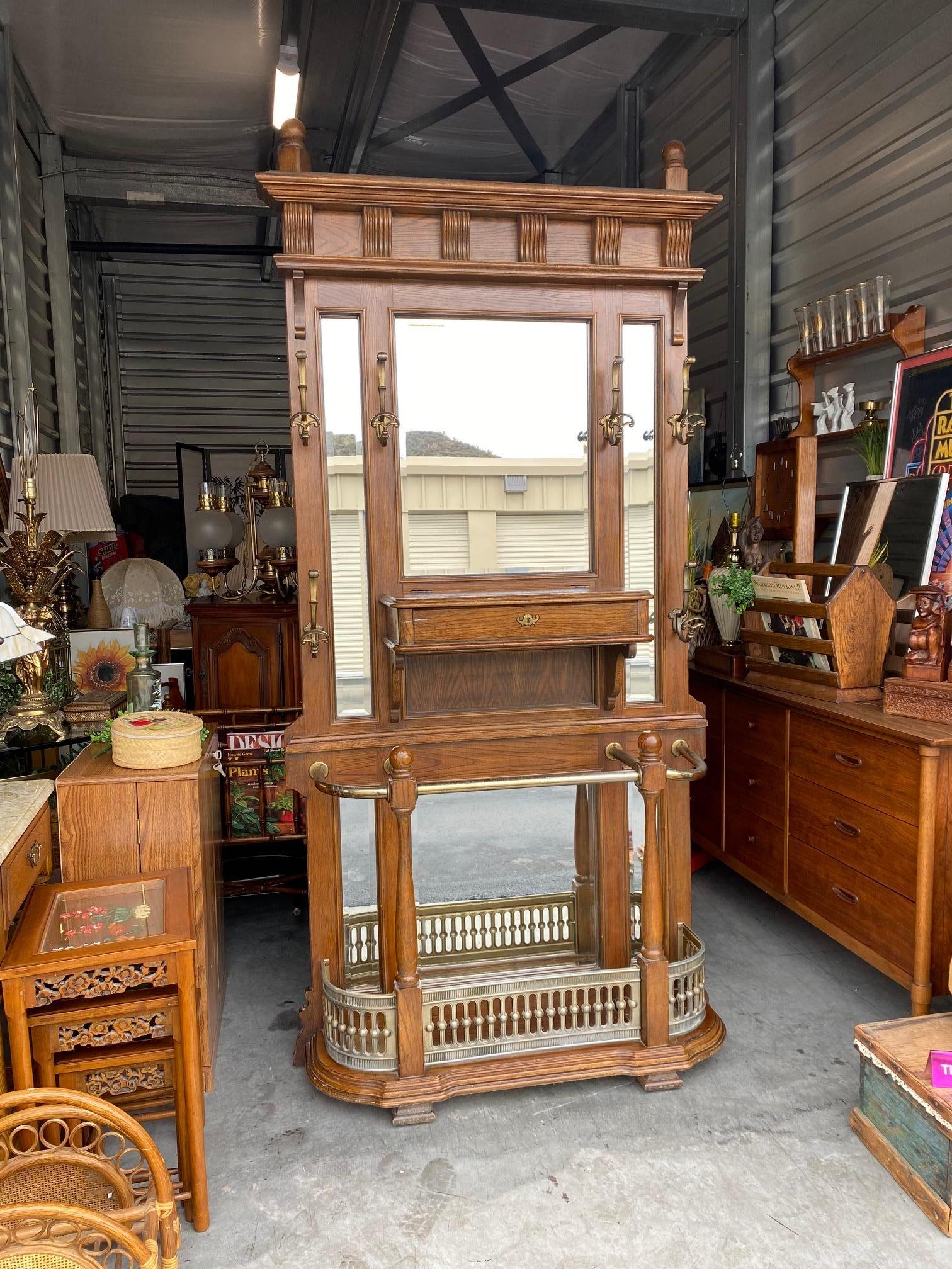 Beautiful brass and wood hall tree with mirrors. This piece is absolutely breath taking. So many nice details throughout. Storage space in the center as well as coat racks and a bottom shelf to hold additional items. The hanging hooks would work