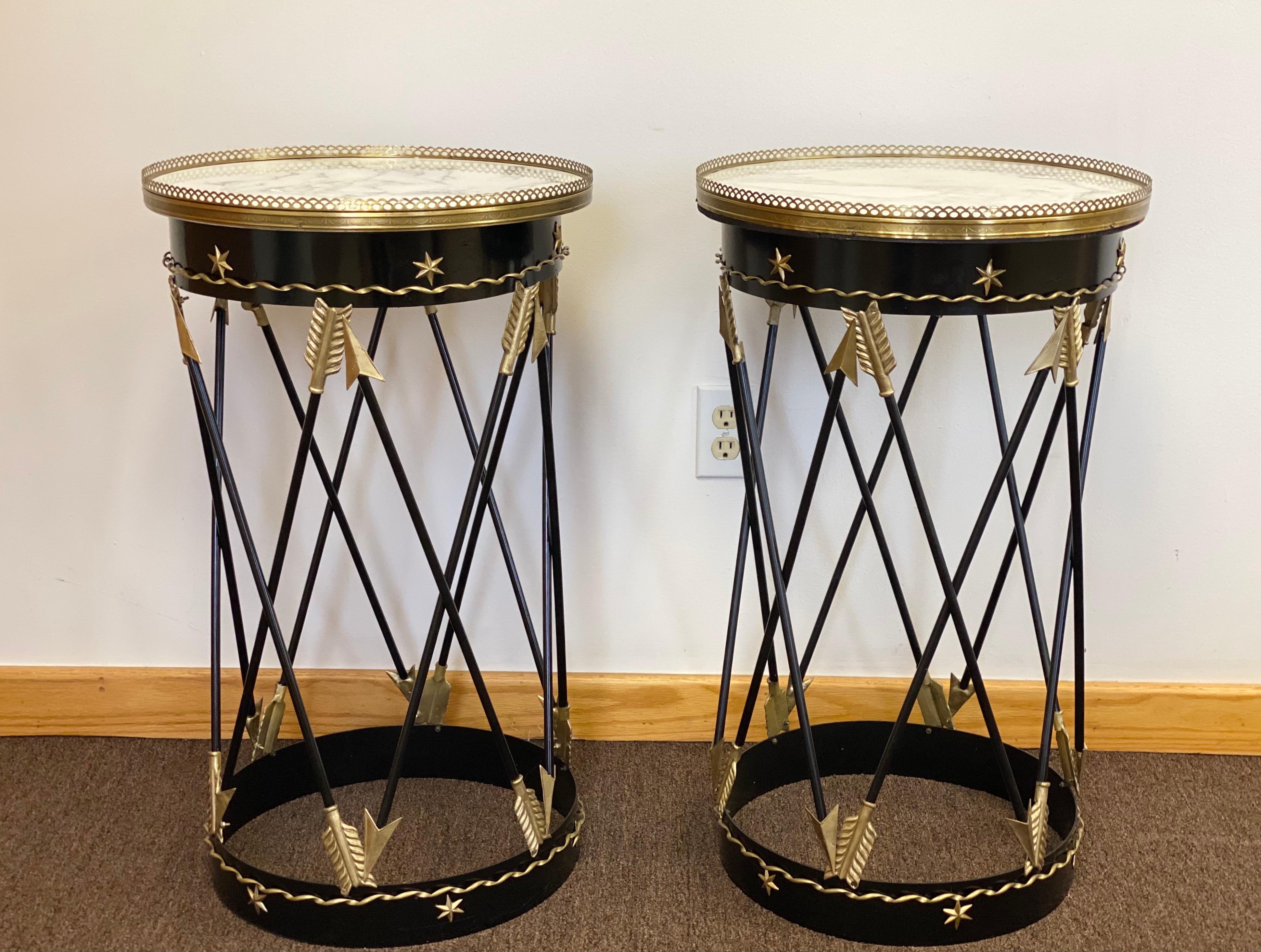 We are very pleased to offer a beautiful, Neoclassical style, restored set of side tables, circa the 1900s. This stunning pair has a wonderful sculptural iron frame and showcases a bronze cross arrow design, gilt roping trim and a brass gallery