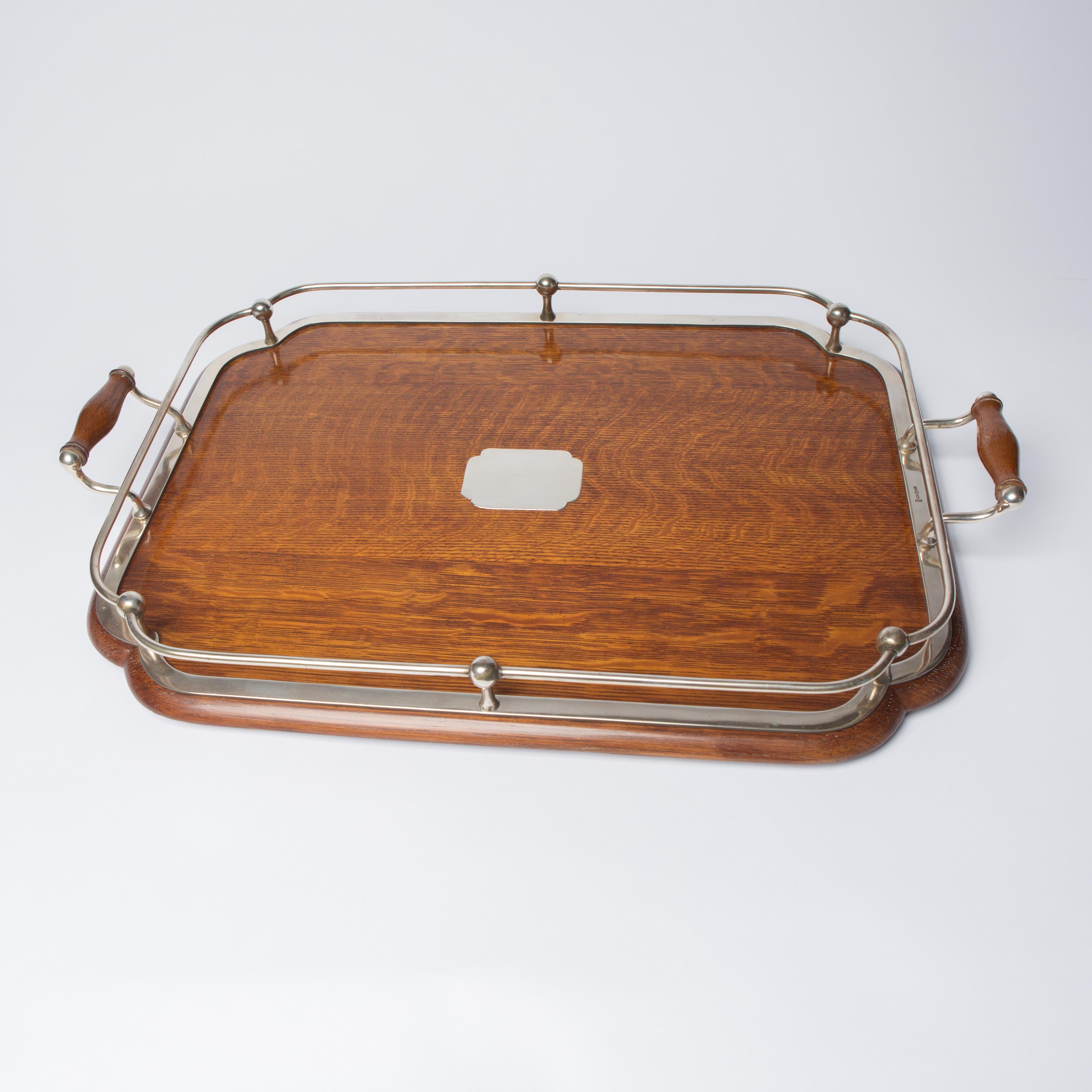 Very smart example of a 19th century oak and silver plated drinks tray. Curved wooden tray with curved corner detailing surround by decorative silver frame with silver and oak handles.