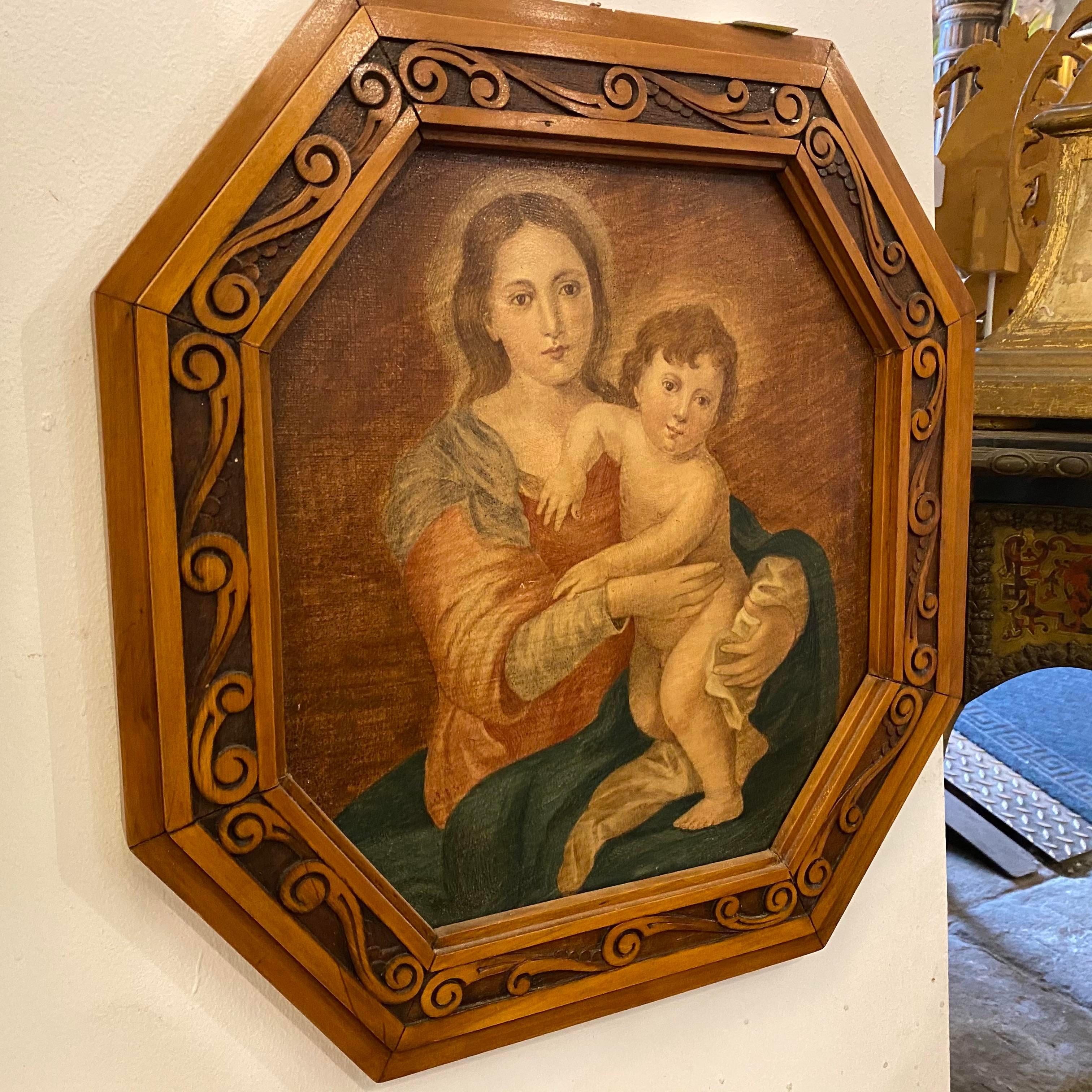 An Italian popolar oil on canvas depicting Madonna and baby Jesus, framed in a hand carved fruitwood frame. It's in perfect conditions.