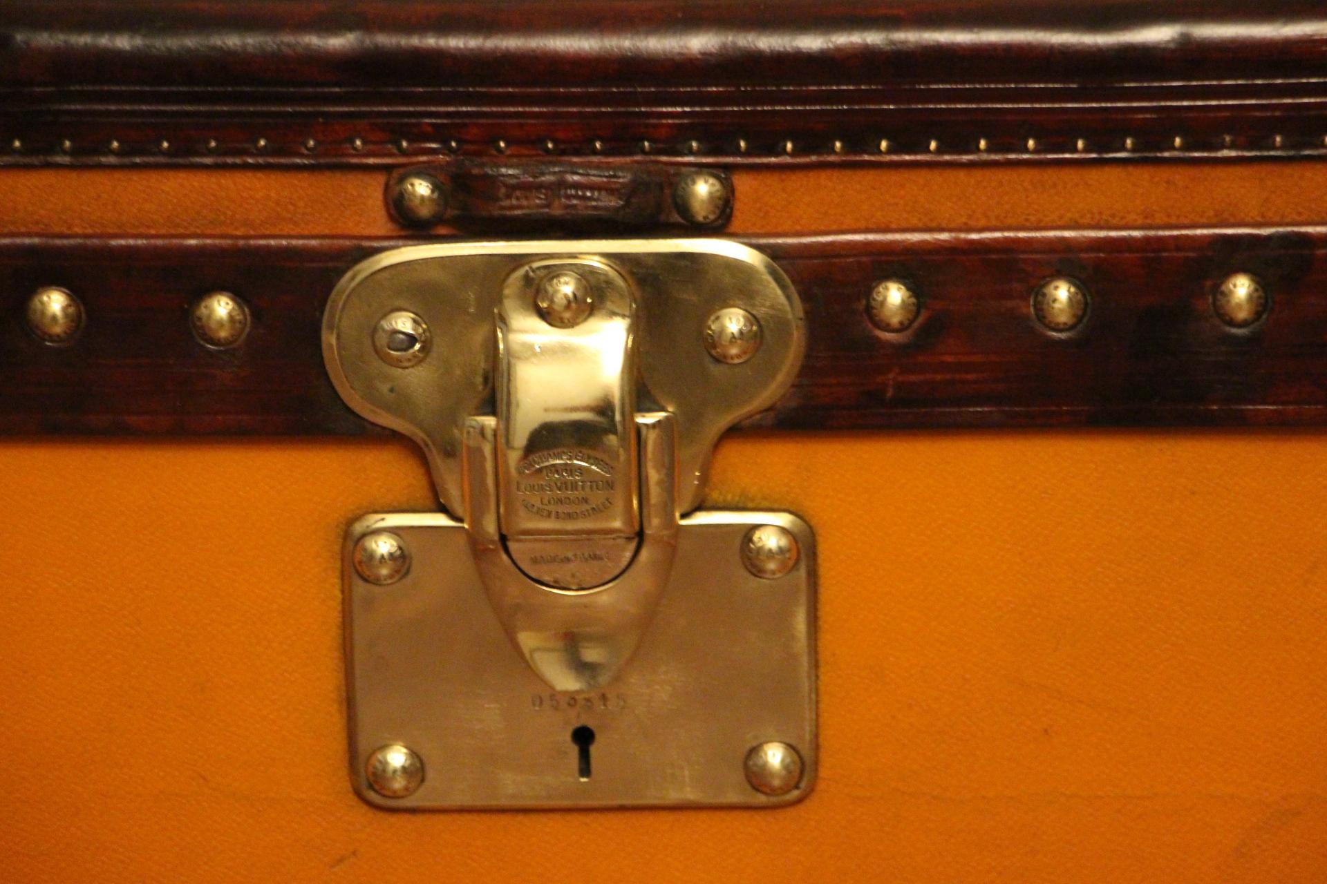 Very nice orange canvas Louis Vuitton steamer trunk, featuring Louis Vuitton stamped brass lock, clasps as well as all its studs. Beautiful and rich honey color leather trim and handles. Unusual and elegant proportions.
It is typically from
