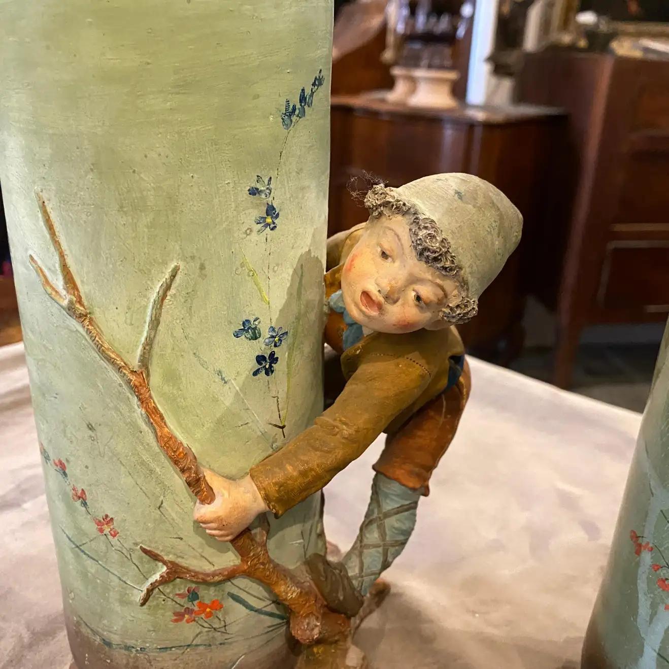 Two rare Art Nouveau ceramic vases made in Italy in 1900. They depicting two children playing. Signs of use and age visible on the photos.