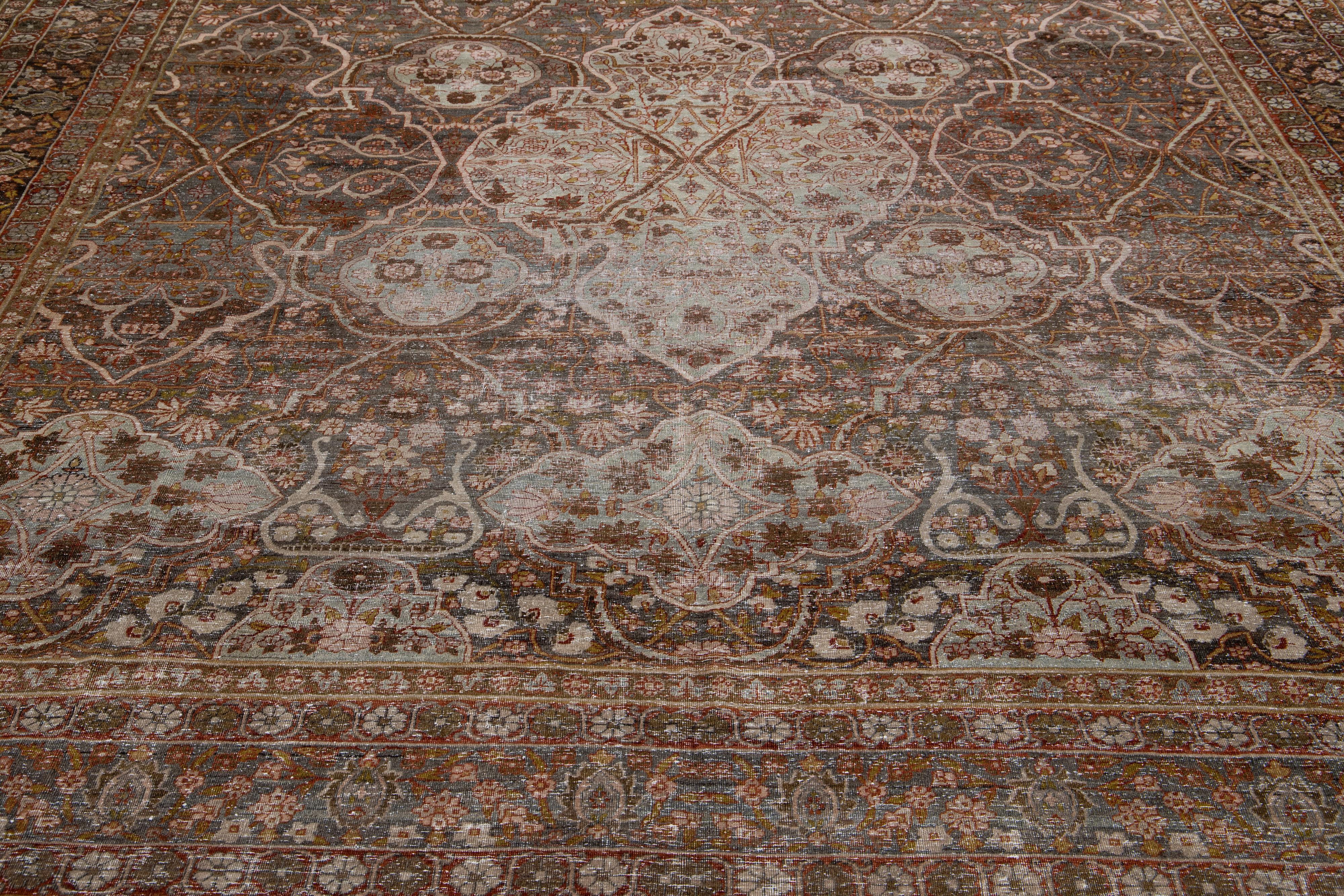 This antique Tabriz rug boasts a gray field and features exquisite, hand knotted wool construction complemented by hints of red, goldenrod, and beige in an all-over floral pattern. This unique craftsmanship is durable and timeless so it can be