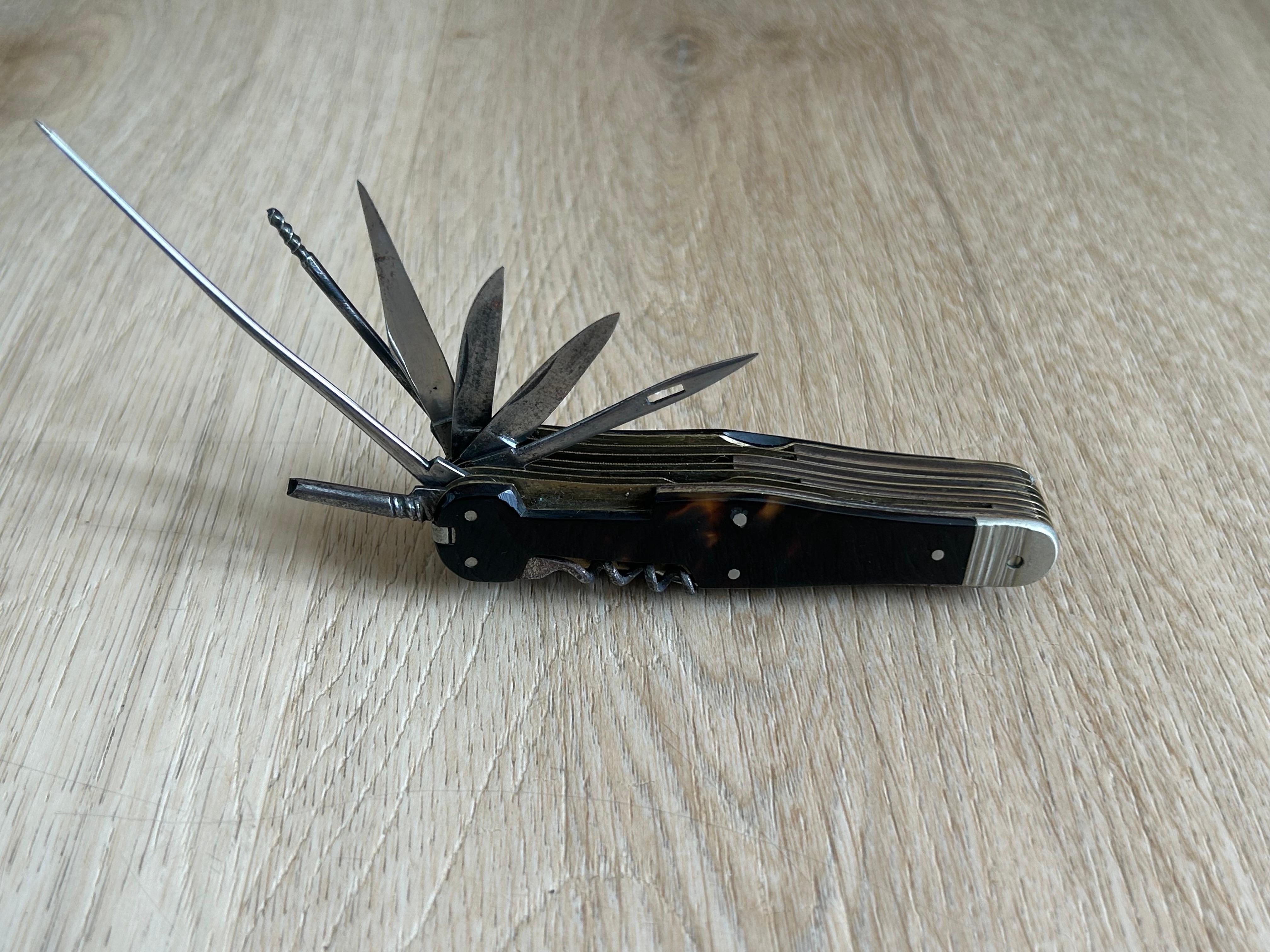 A rare early tortoiseshell 'Swiss Army' Pen Knife, c. 1900, containing a multitude of blades and other useful implements, 9 cm long. The Swiss Army knife (German: Schweizer Offiziersmesser) is a pocket knife or multi-tool manufactured by Victorinox