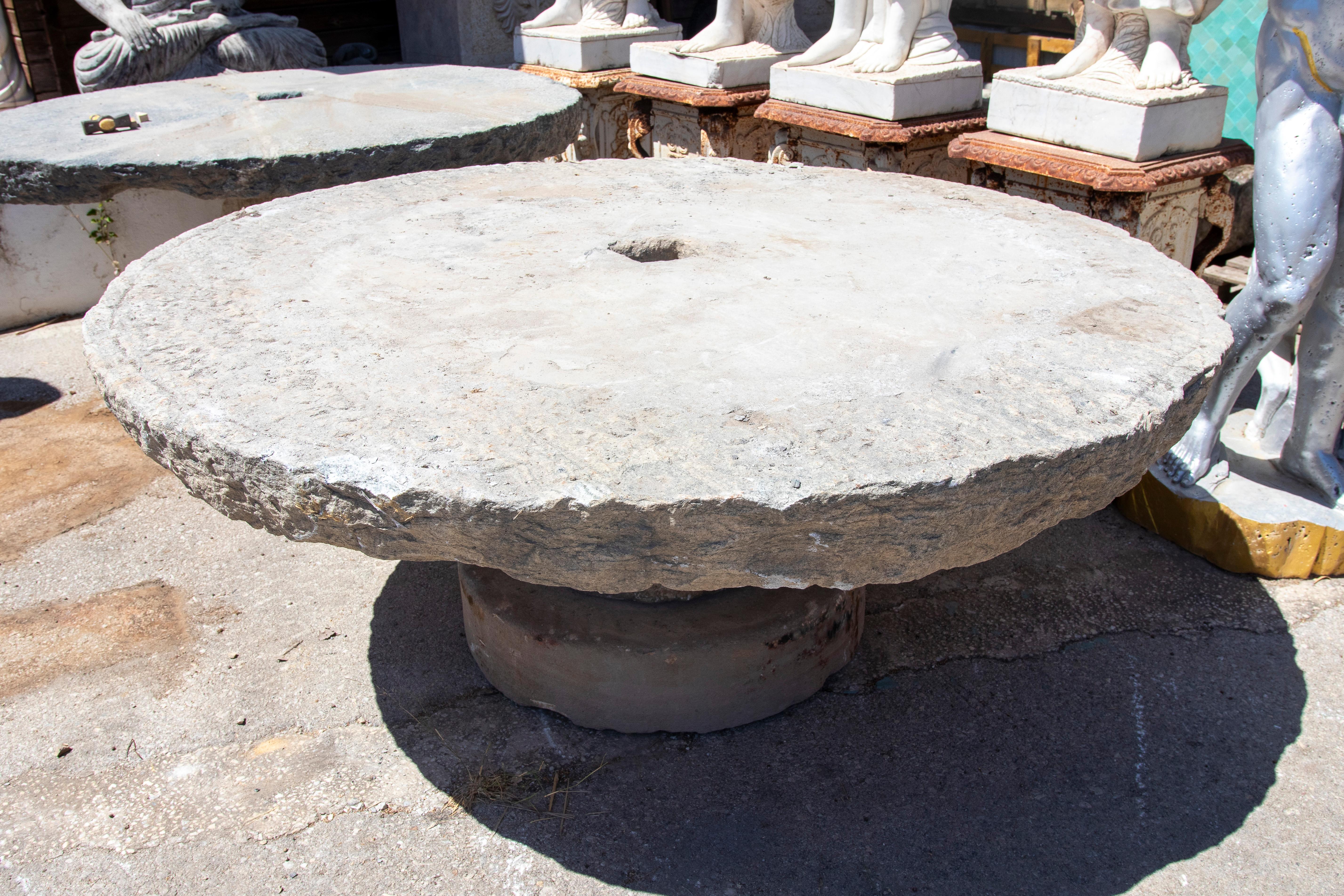 Mesa circular de piedra rústica de 1900 con acabado natural y abertura central en venta 4