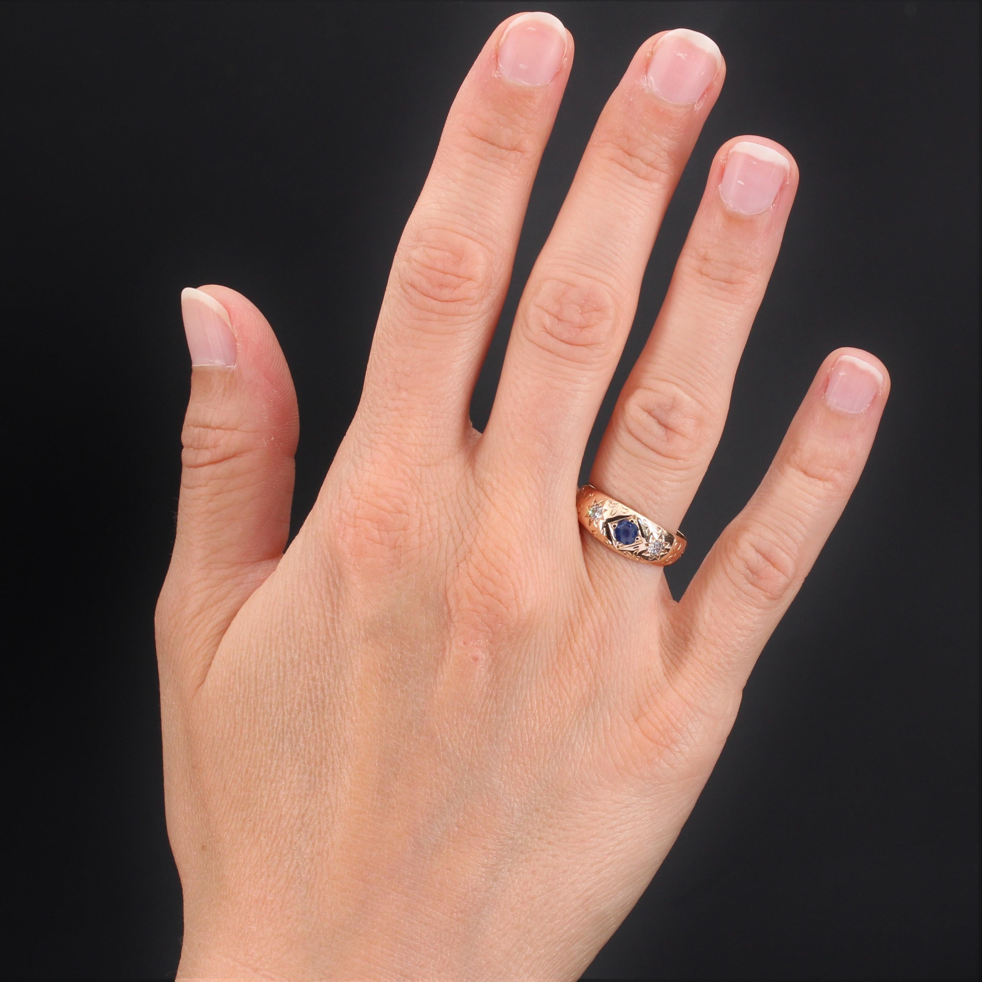 Ring in 14 karat rose gold, shell hallmark.
Pretty antique ring in rose gold, it is chiseled of decorations in arabesques and fleur de lys. In the center is a round sapphire in a square design accompanied on both sides by 2 x 1 diamond in star