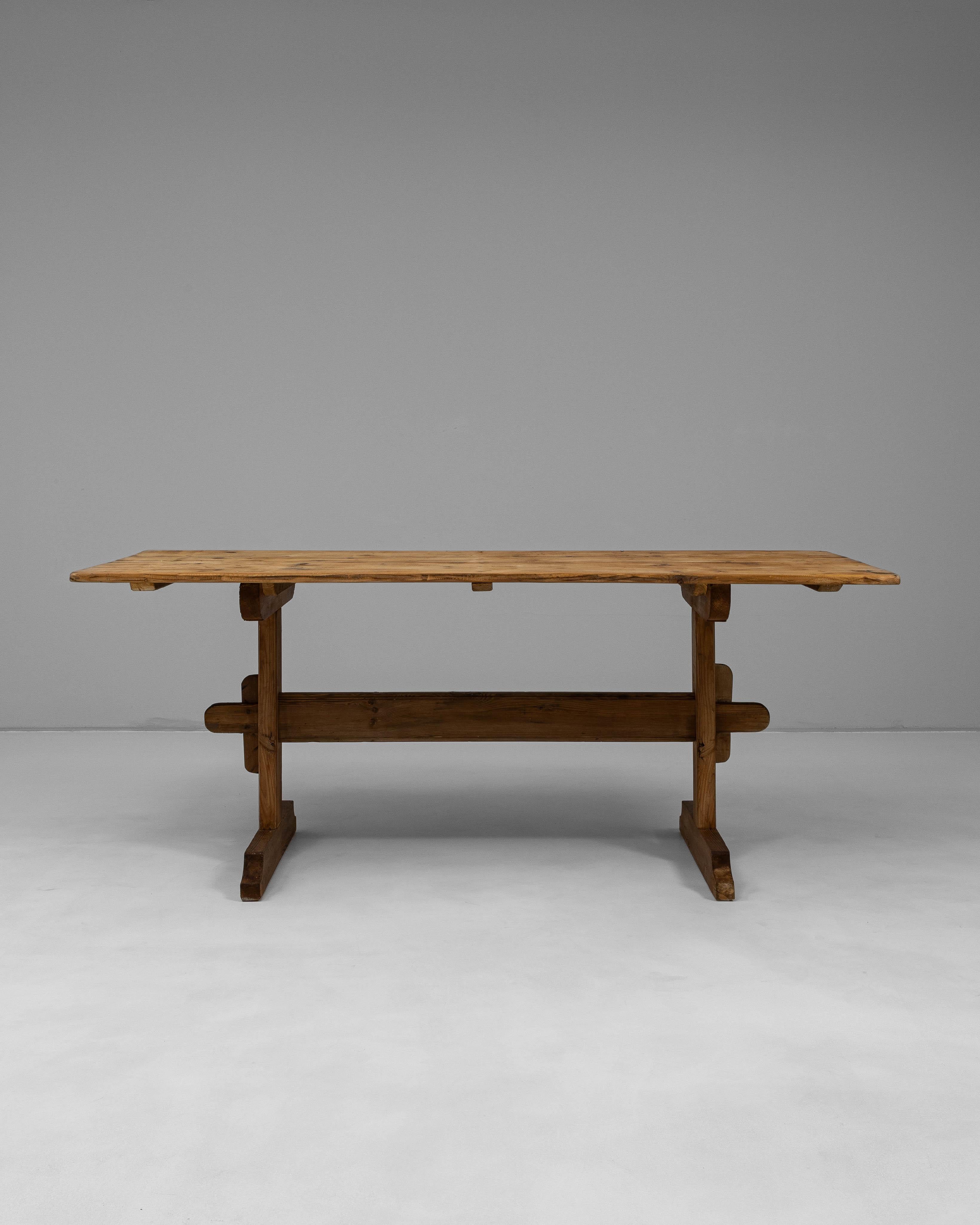 Cette table de salle à manger à tréteaux en pin scandinave des années 1900 reflète l'honnêteté de l'artisanat et l'élégance fonctionnelle caractéristiques du design rural nordique. Construite en pin massif, la table présente une surface chaude et