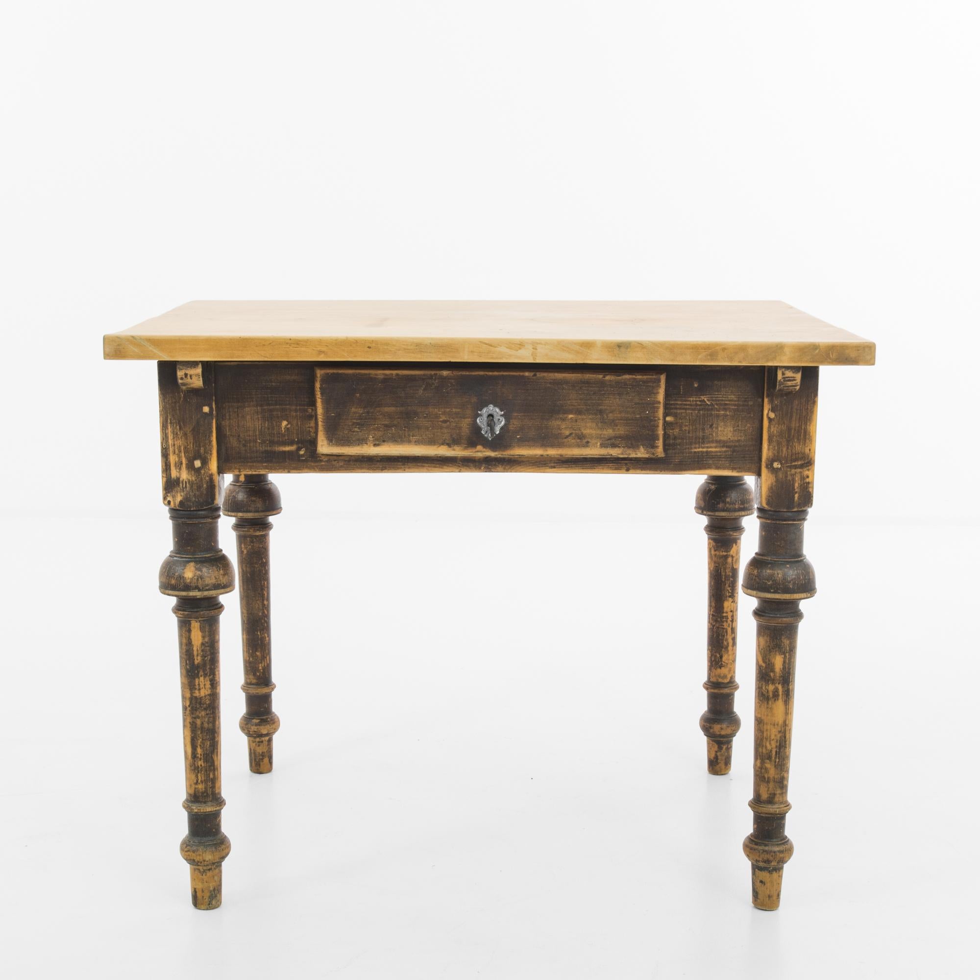 A wooden table from Scandinavia, produced circa 1900. A graceful side table featuring a sliding drawer with original lock and key. Looking like it sprang from a Hans Christen Andersen tale, this charming antique will add a touch of history and