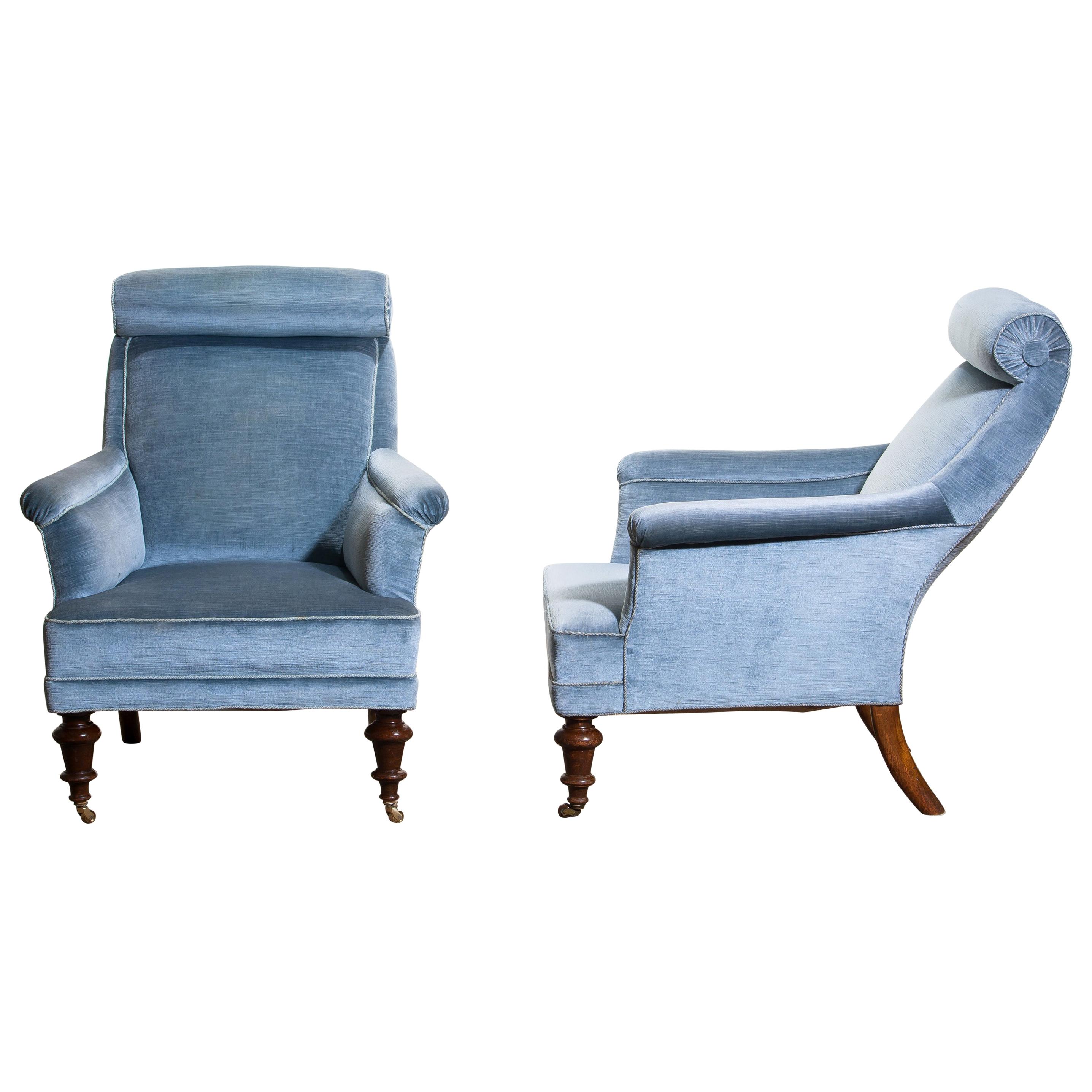 Rare and extremely comfortable / beautiful set of two bergère / lounge chairs in Dorothy Draper style from the turn to the 20th century.
Both chairs are upholstered in ice blue velvet and in good condition.

One chair has new wheels in brass and