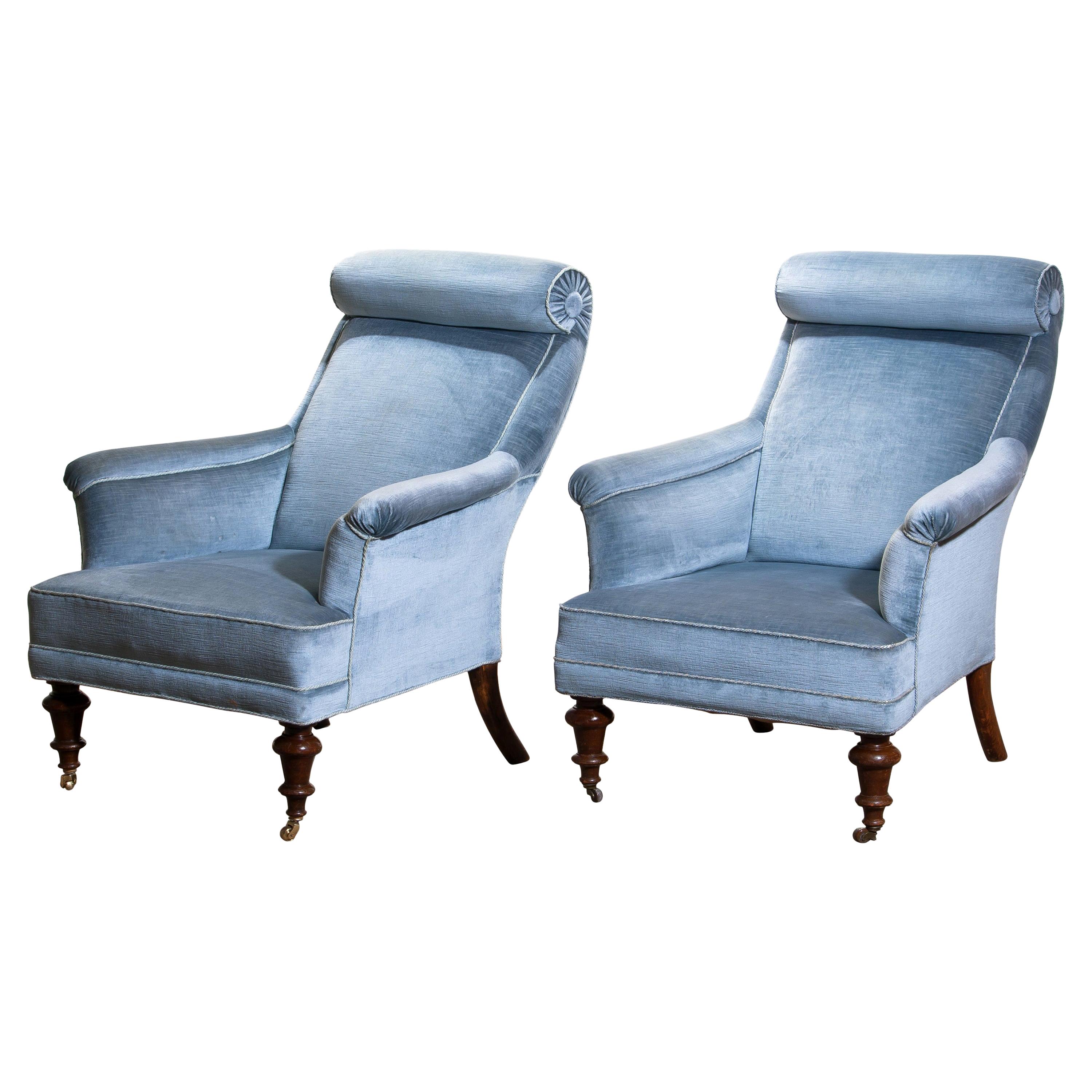 Rare and extremely comfortable / beautiful set of two bergère/ lounge chairs in Dorothy Draper style from the turn to the 20th century.
Both chairs are upholstered in ice blue velvet and in good condition.

One chair has new wheels in brass and