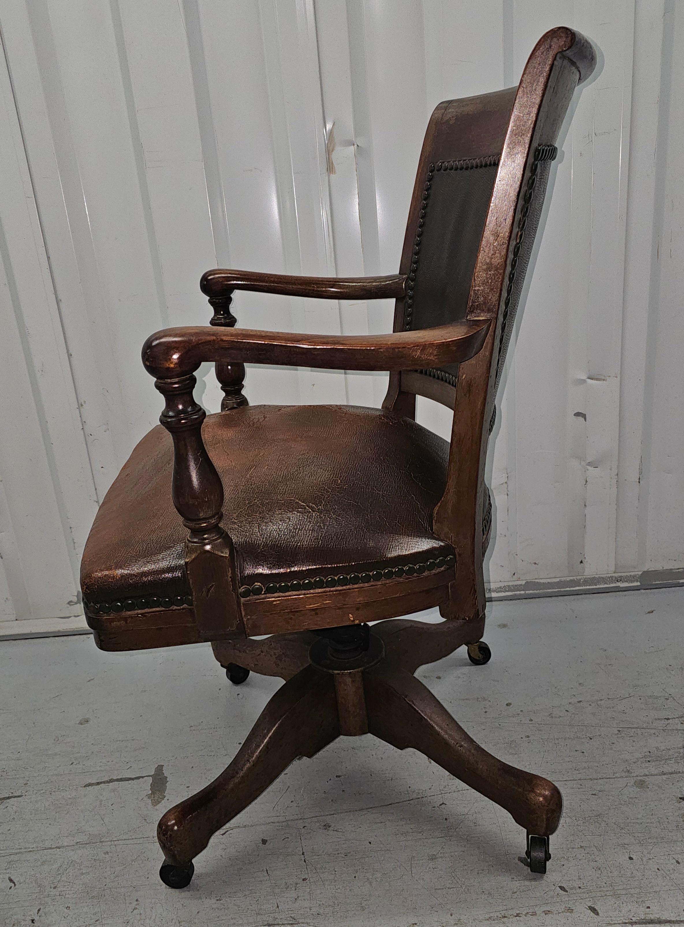 A 1900s Sikes Furniture Company Walnut and Leather Upholstered Seat and back rolling desk chair. Swivels and tilts. Firm springed seat. Beautiful nail head trims
Some wear on leather seat , but tear. Measures 24