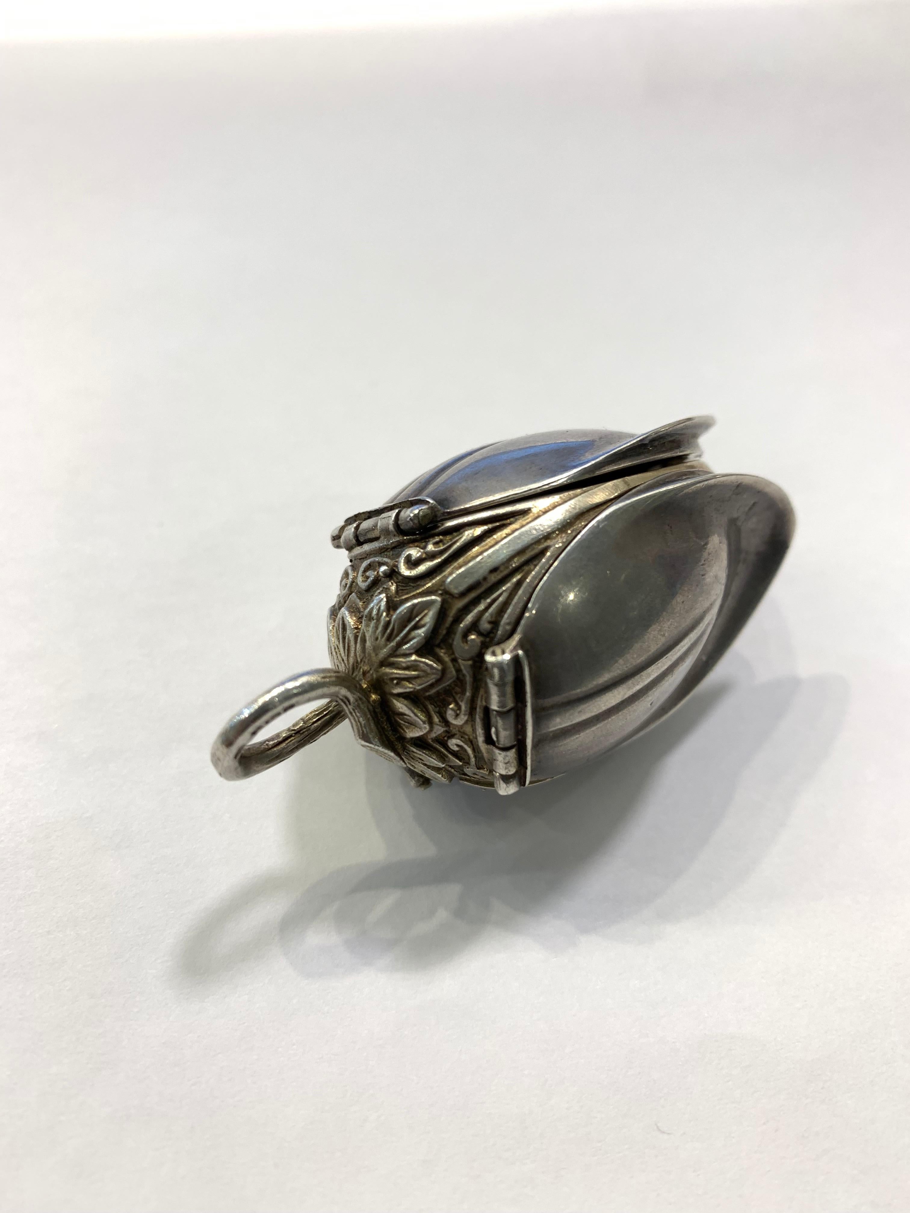 A beautifully crafted English silver antique watch locket in the style of a tulip flower bud. This is a rare stunning piece of jewelry that would make a great addition to any collection. Each 'petal' opens up revealing the original bronze watch with