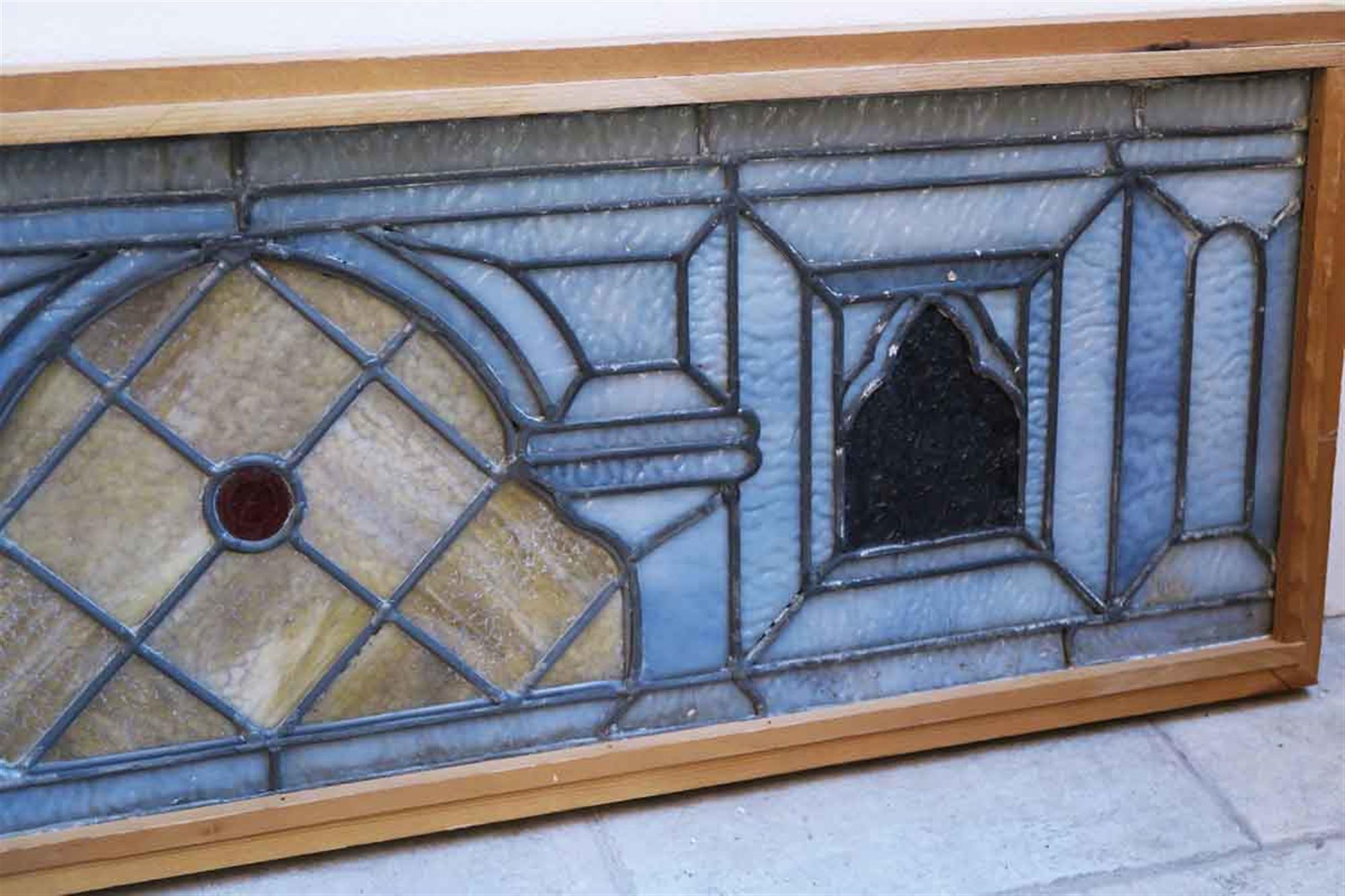 Wood frame antique stained glass window with a red jewel in the center. Placed in a new wood frame. This can be seen at our 5 East 16th St location on Union Square in Manhattan.