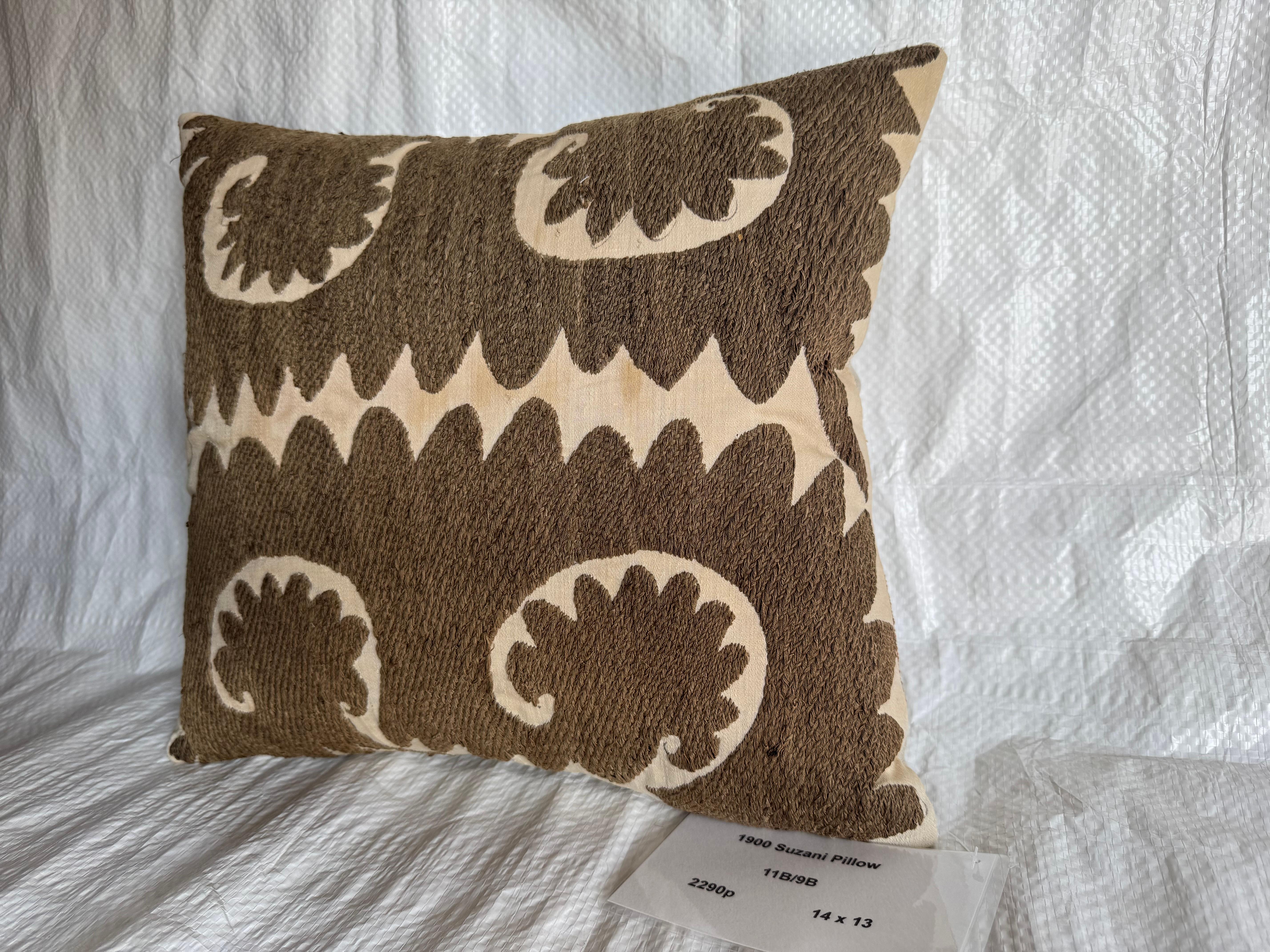 Questo cuscino decorativo è realizzato con un tessuto Suzani ricamato a mano dei primi del '900. Il design è caratterizzato da un audace motivo vorticoso su larga scala in verde intenso su un fondo avorio, creando un look grafico e sorprendente.

I