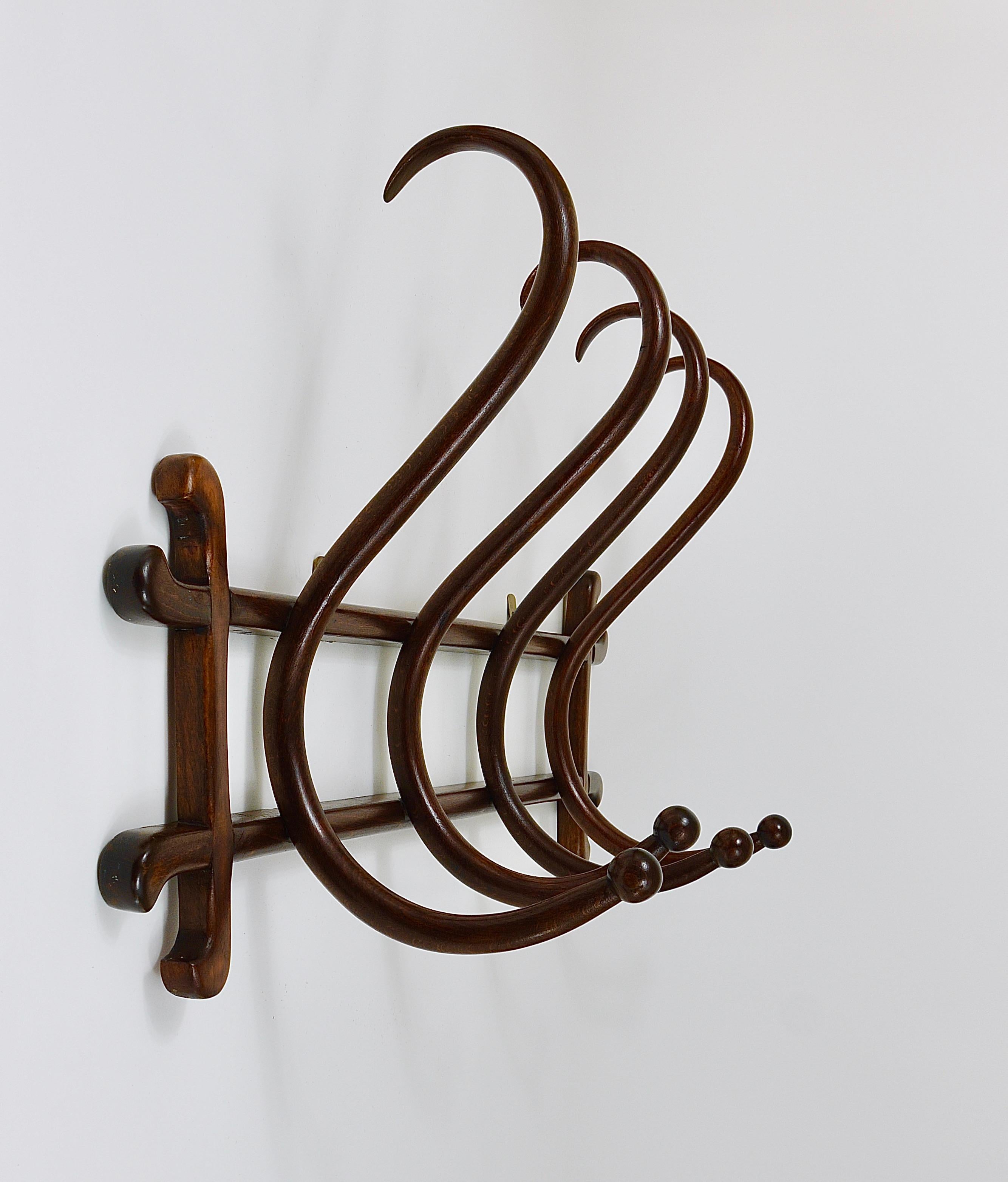 A beautiful original authentic Art Nouveau wall-mounted coat and hat rack / wooden wall hanger, dated around 1900, executed by Thonet Vienna, Austria. This wardrobe is made of dark brown bentwood with four S-shaped hooks. In good condition with